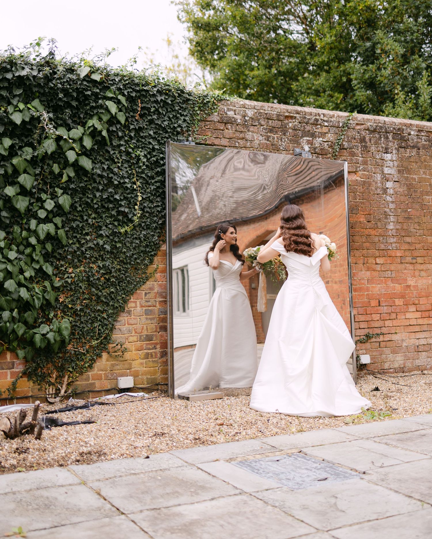 Sequential photos of a wedding dress train being arranged on stone pavement.