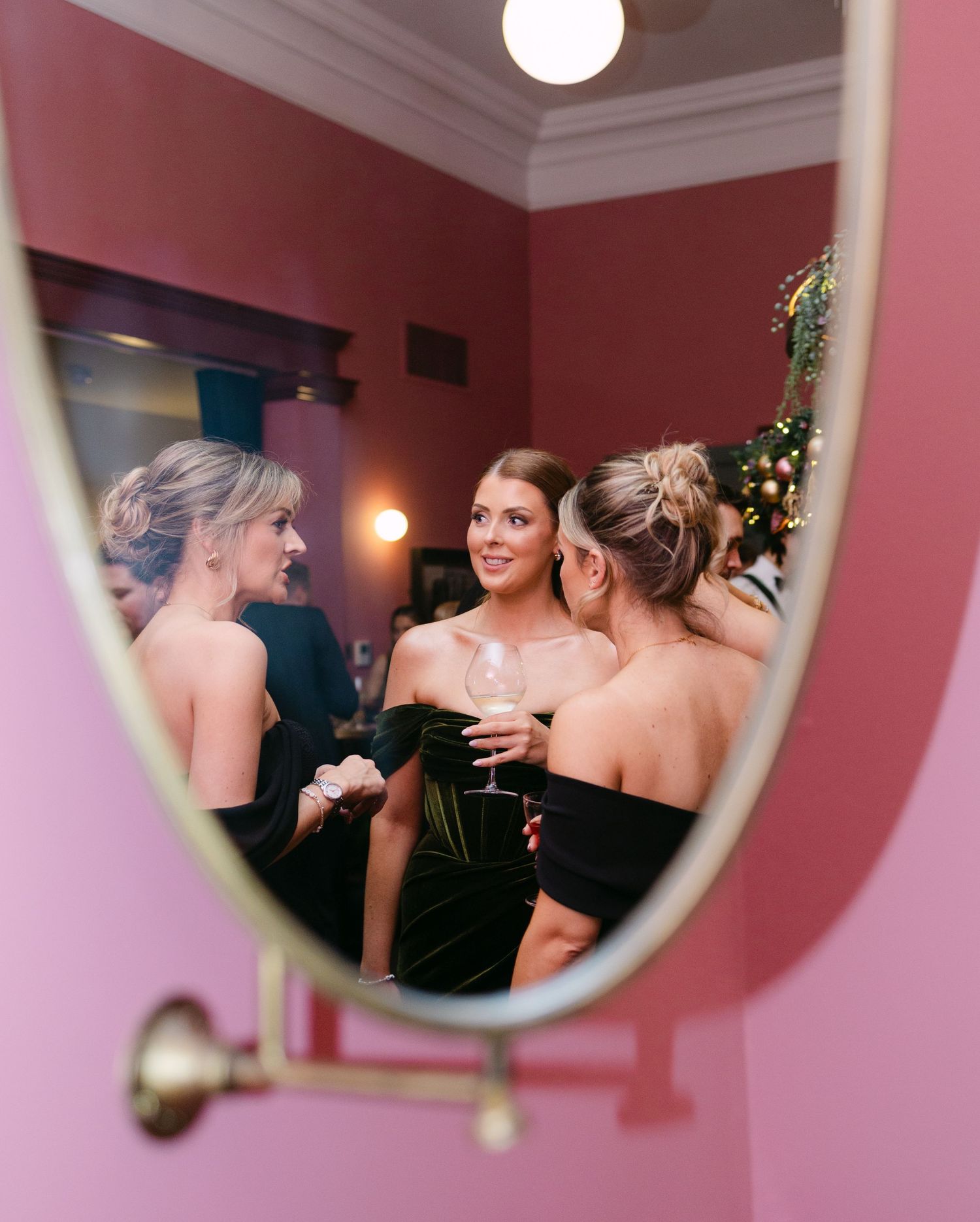 A shot through the mirror upstairs in Kindred, Hammersmith of wedding guests chatting together