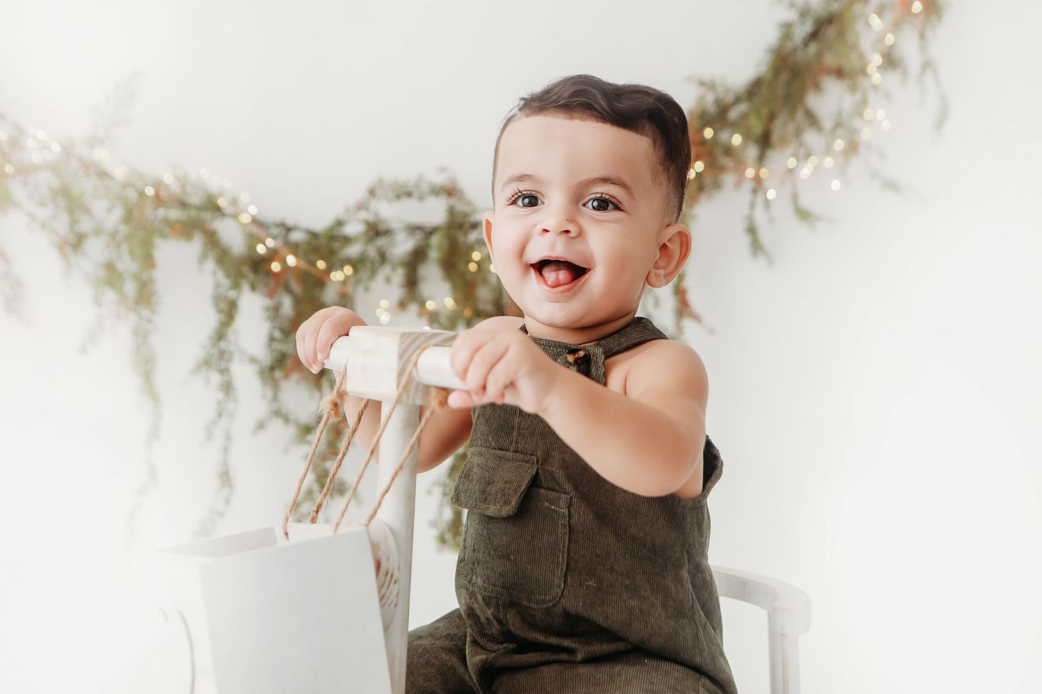 Rustic floral garland decorates white photography backdrop.