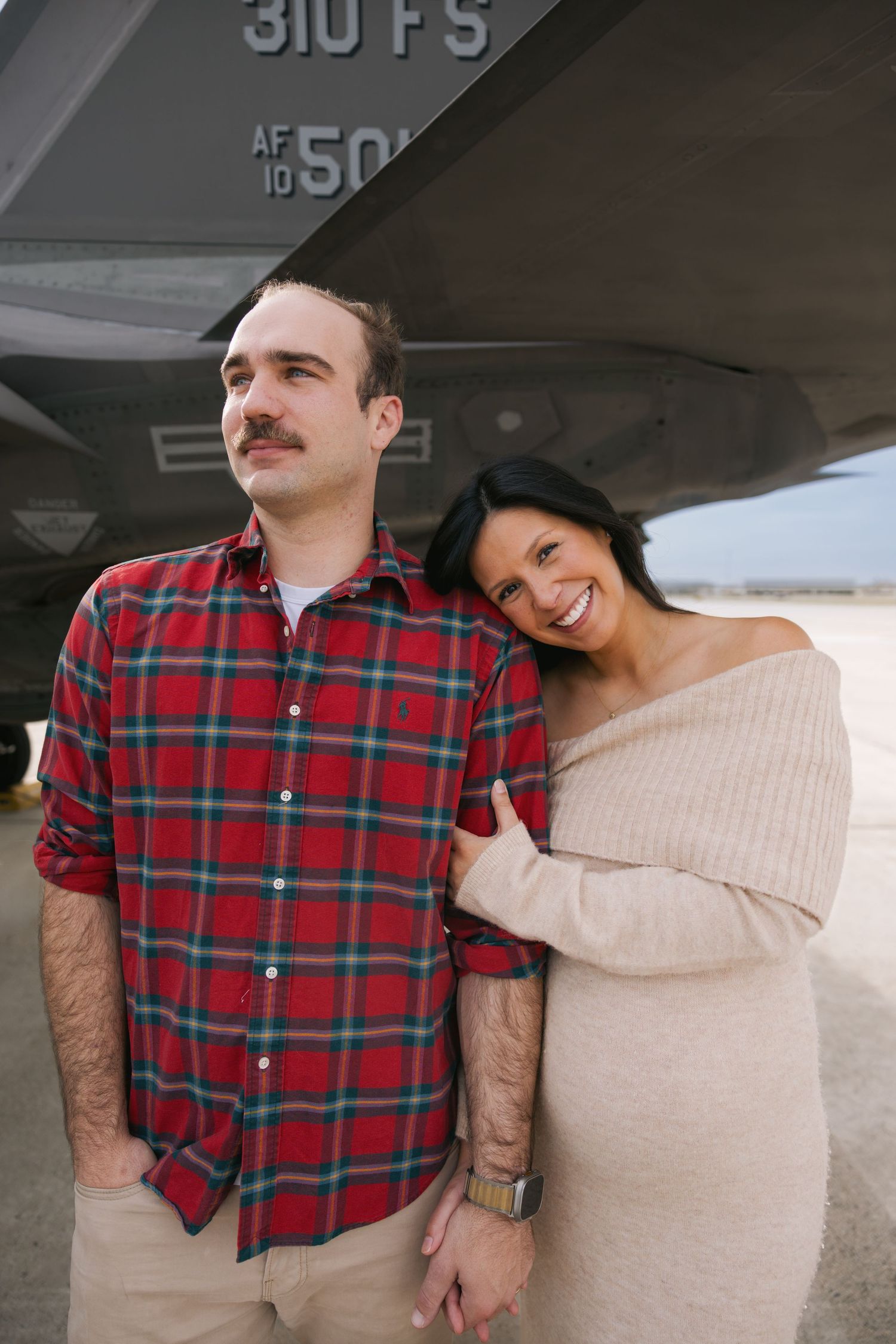 Military couple standing under F-15 jet Luke AFB, photographed by Rhen Marie Photography