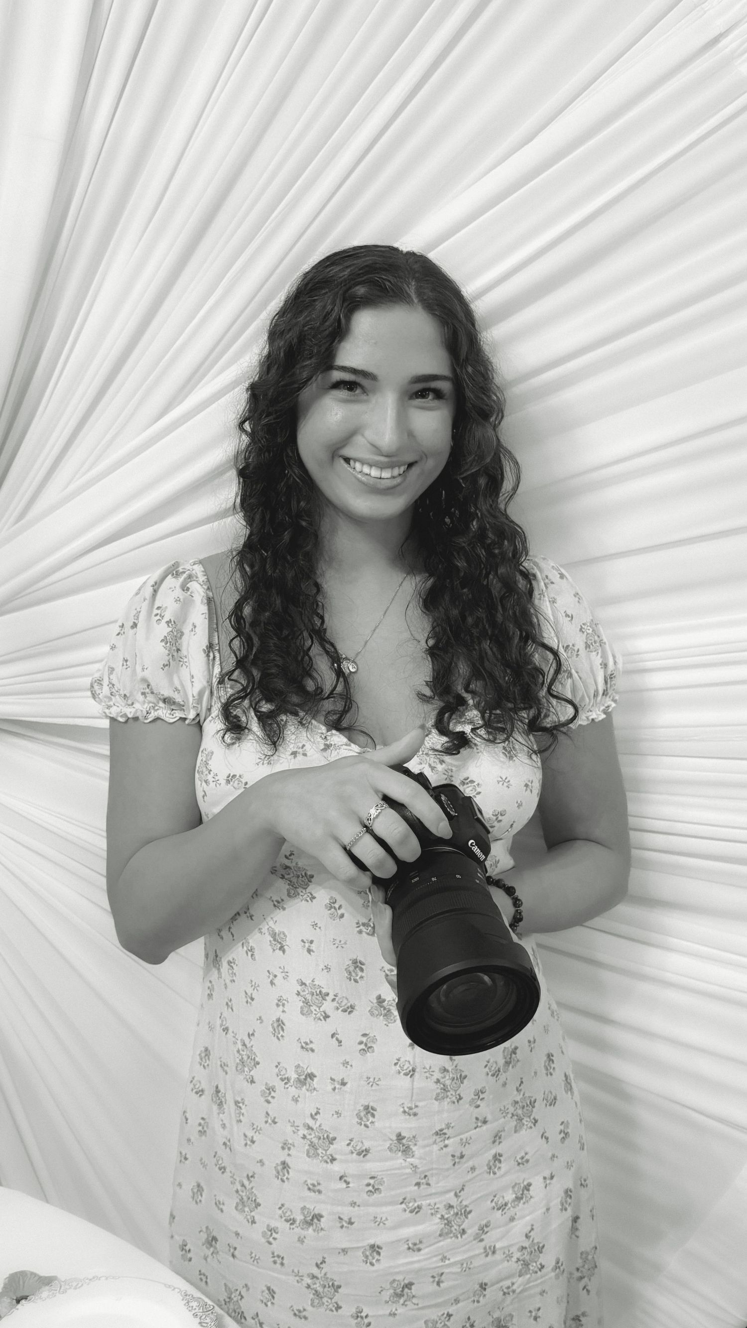 Photographer holding camera in a stylish studio setup, black-and-white portrait, Rhen Marie Photography