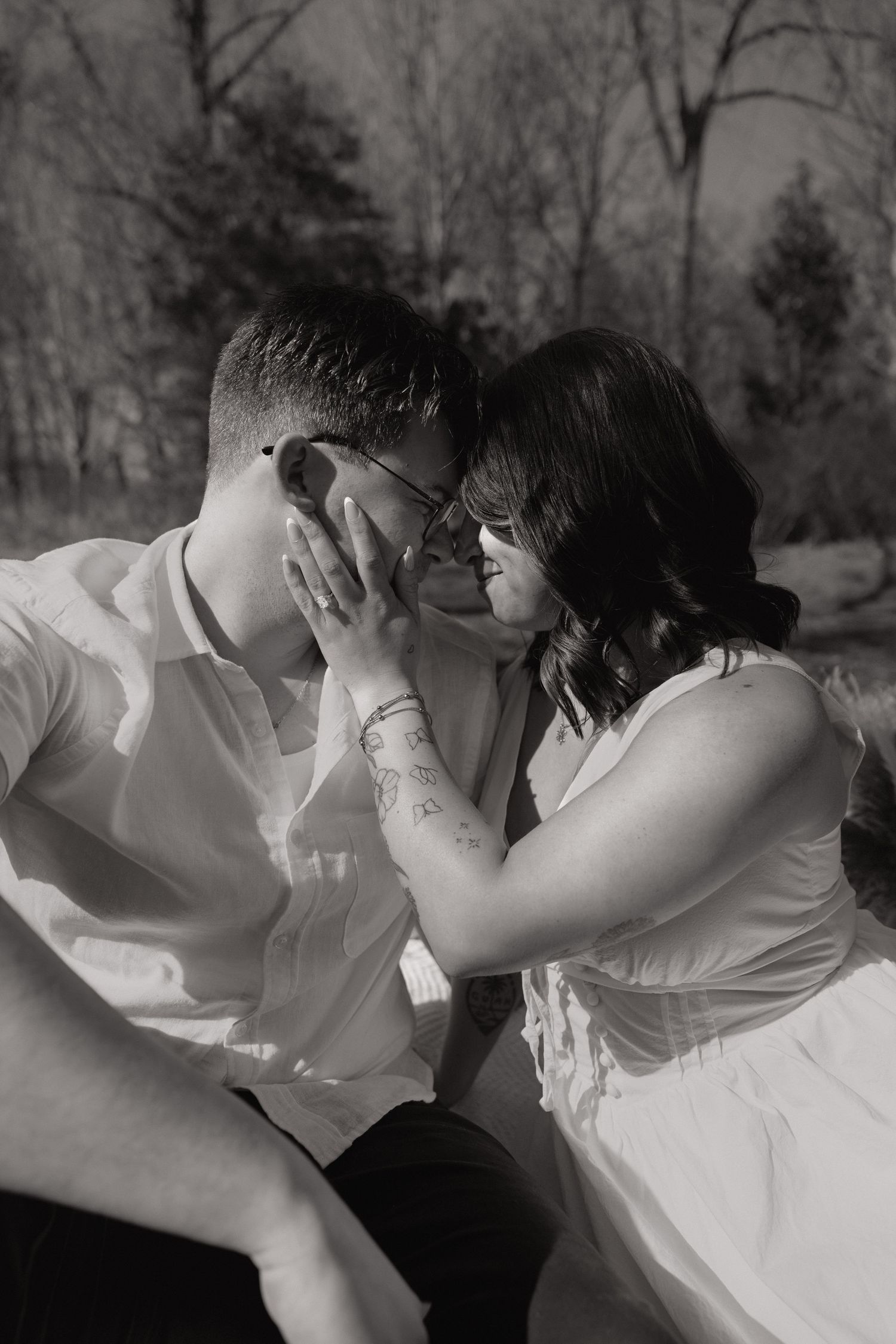Couple sharing an intimate moment outdoors in the DMV, black-and-white engagement session captured by Rhen Marie Photography