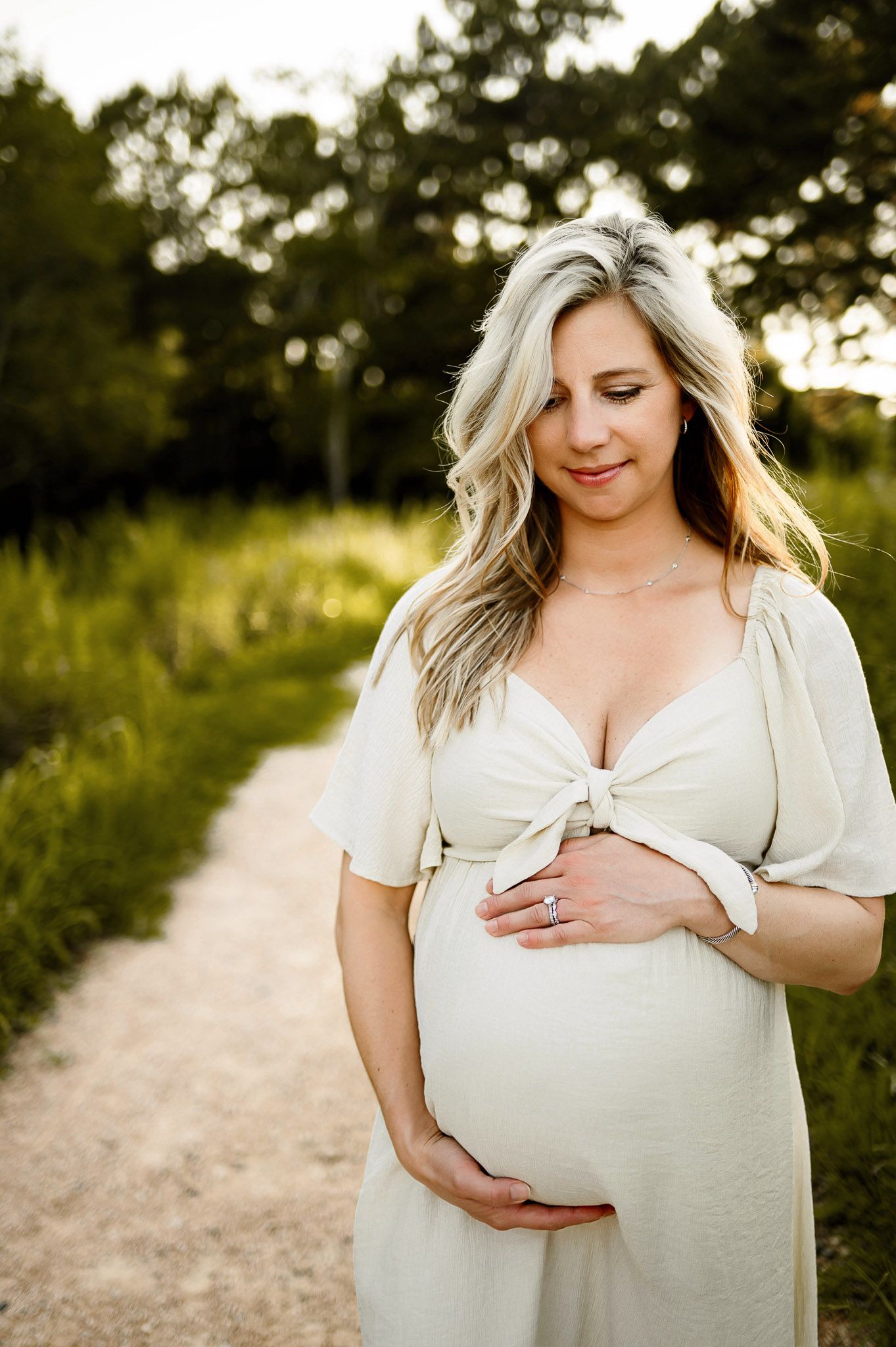 Pregnant mother holding her baby bump during a natural light maternity photography session in Raleigh North Carolina