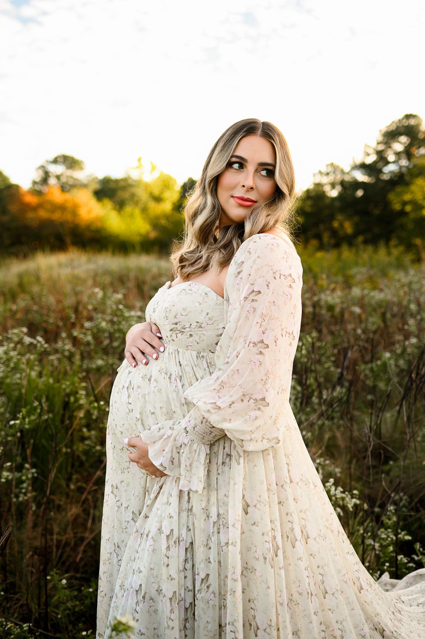 Expecting mother standing in a field during a natural light outdoor maternity photography session near Raleigh North Carolina