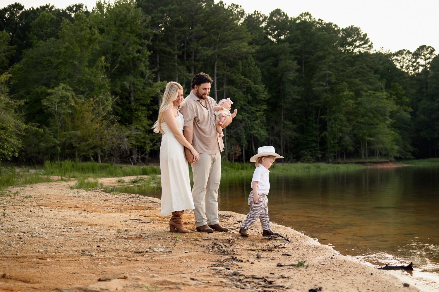 Family of four walking along the lake during an outdoor family photography session in Raleigh, NC