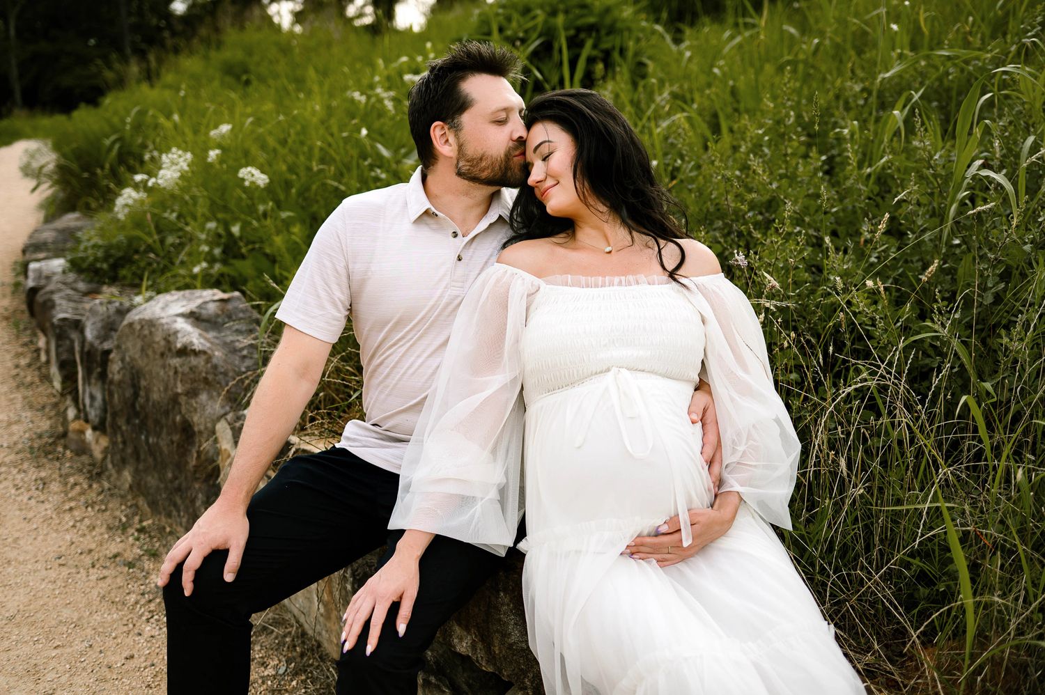 Expectant couple sitting together during a relaxed outdoor maternity photography session in Raleigh NC