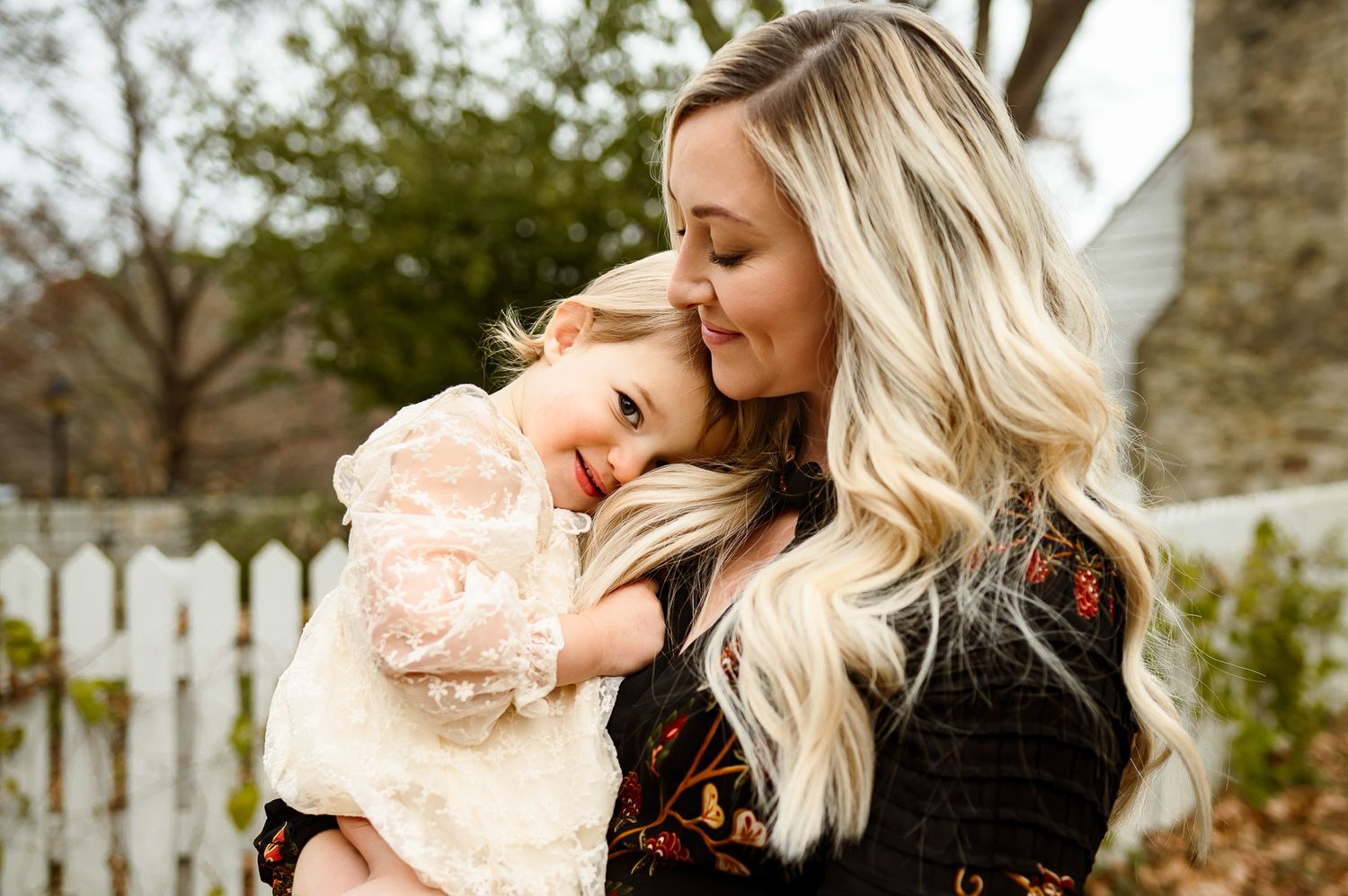 Toddler resting her head on her mother's shoulder during a natural outdoor family photography session in Knightdale NC