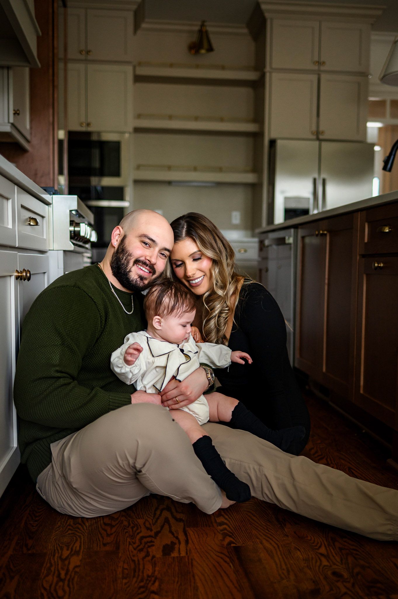 Parents sitting on the kitchen floor with their baby during a candid lifestyle family photography session at home