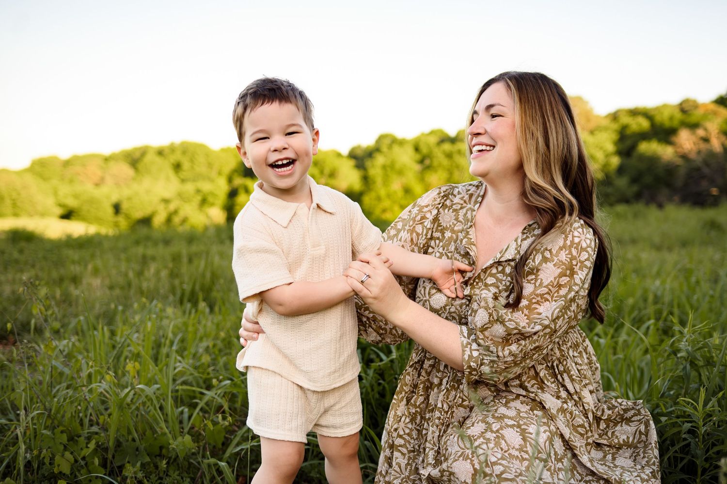 Mom and toddler laughing together during outdoor family photography session in Raleigh