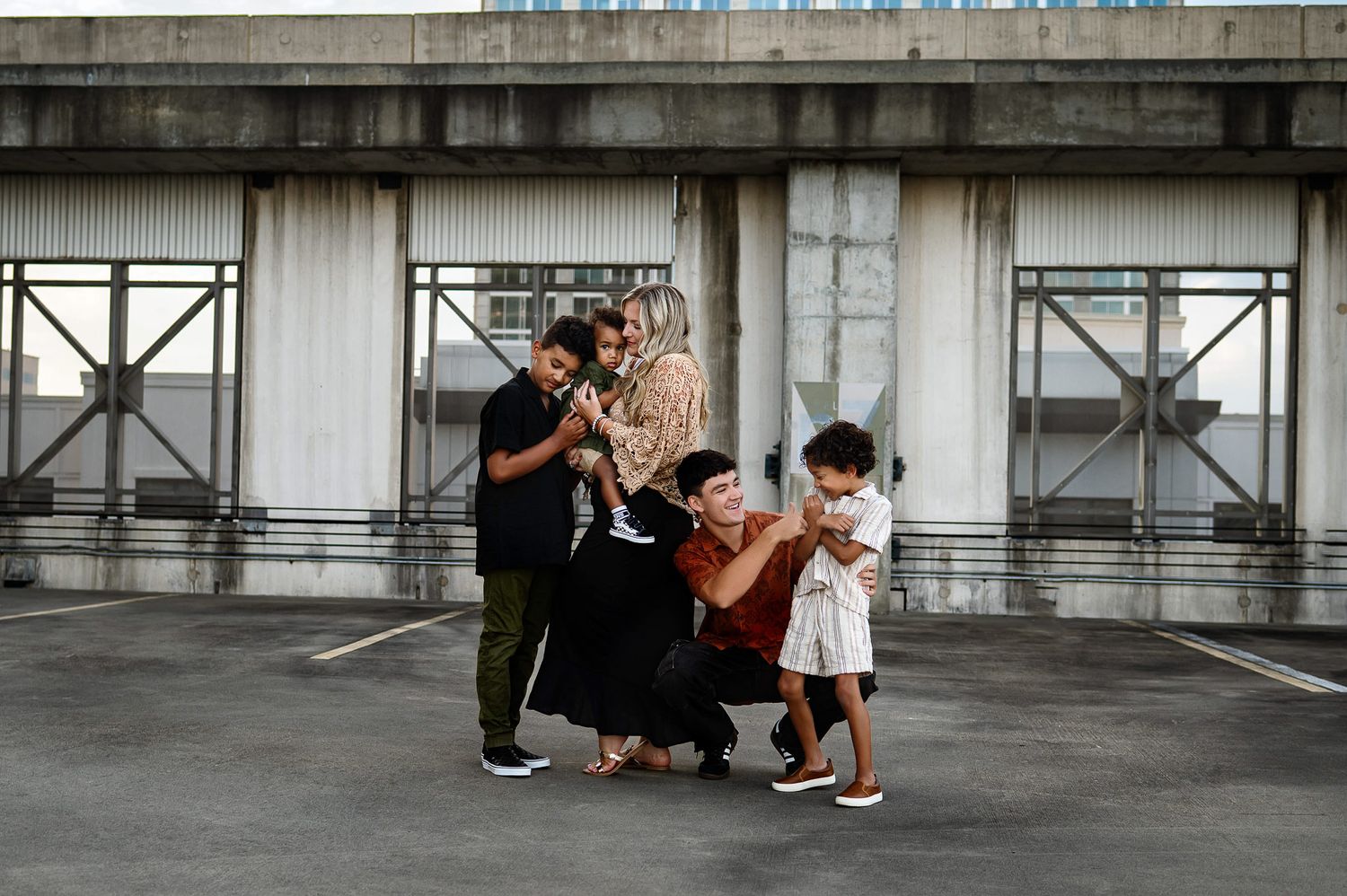 Family gathered together on a rooftop during a relaxed urban lifestyle family photography session in Raleigh NC