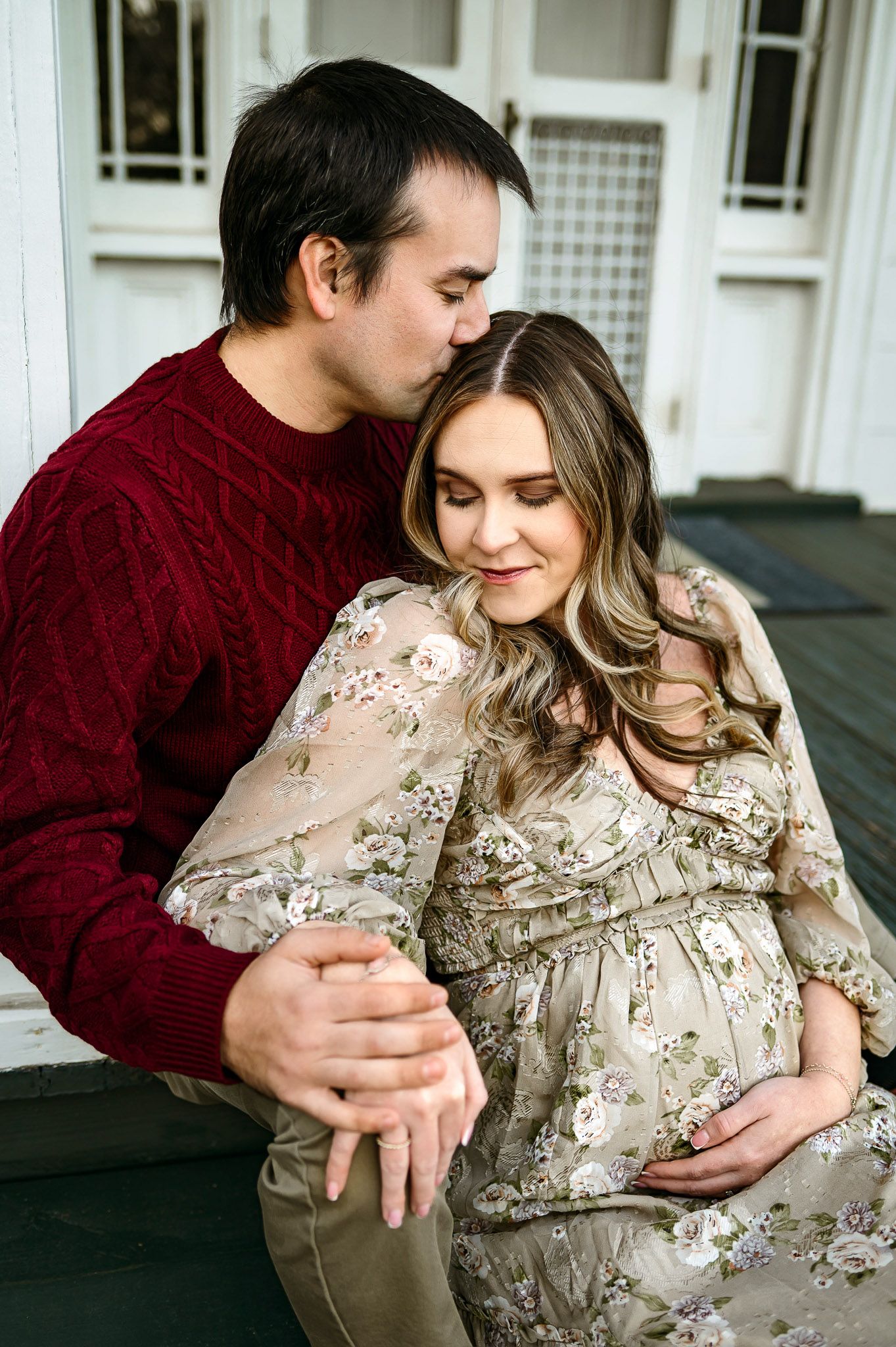 Expecting father kissing mother’s head during a maternity photography session near Raleigh NC
