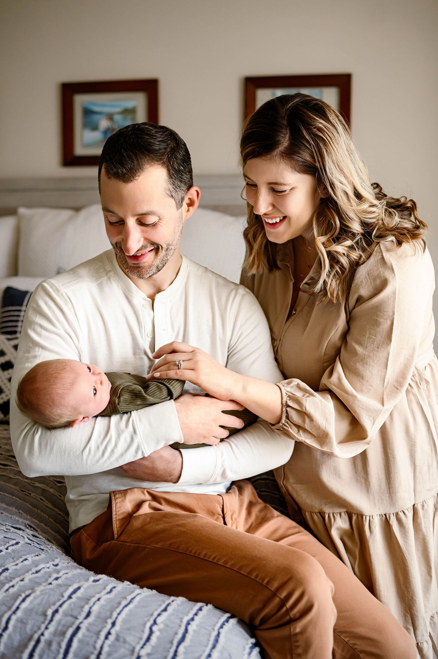 Parents smiling at their awake newborn during an in-home newborn photography session in Raleigh NC