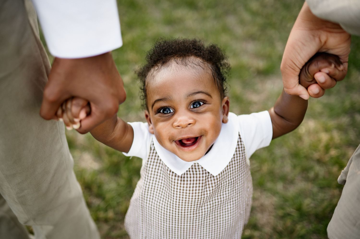 Smiling baby holding both siblings hands during a family photography session in Raleigh North Carolina