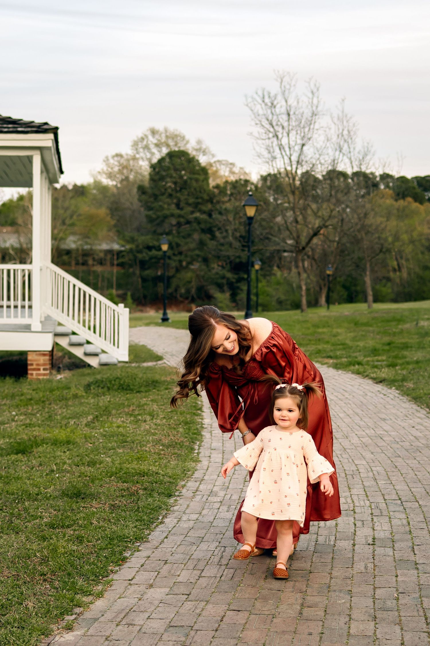 Mom walking with toddler during relaxed outdoor family photo session in Raleigh NC