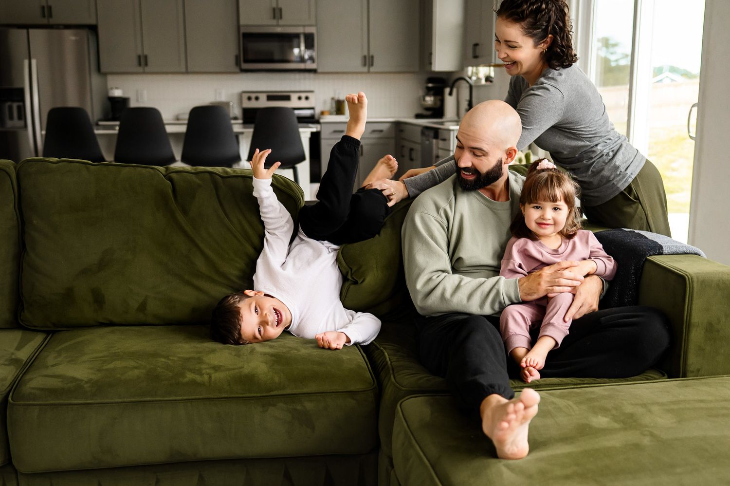 Playful candid moment with parents and children during an in-home family photography session in Wake Forest North Carolina