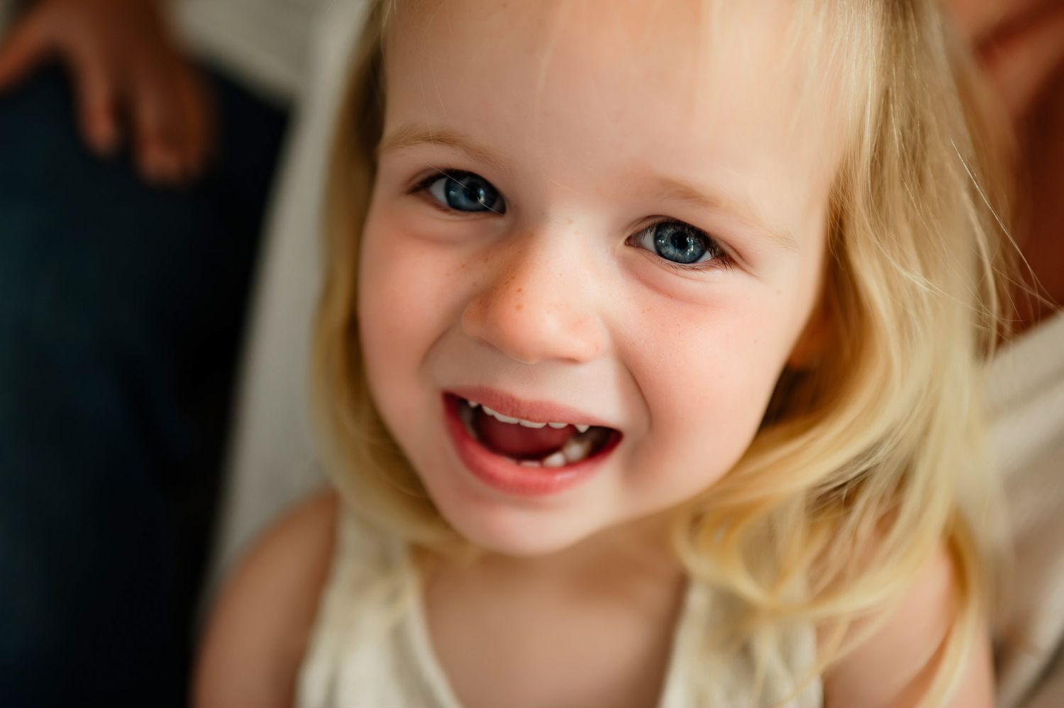Close-up portrait of a smiling toddler girl during an in-home lifestyle family photography session in Apex NC