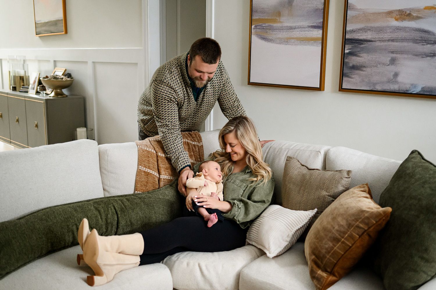 Parents spending time with their baby together on the couch during an in-home lifestyle family photography session