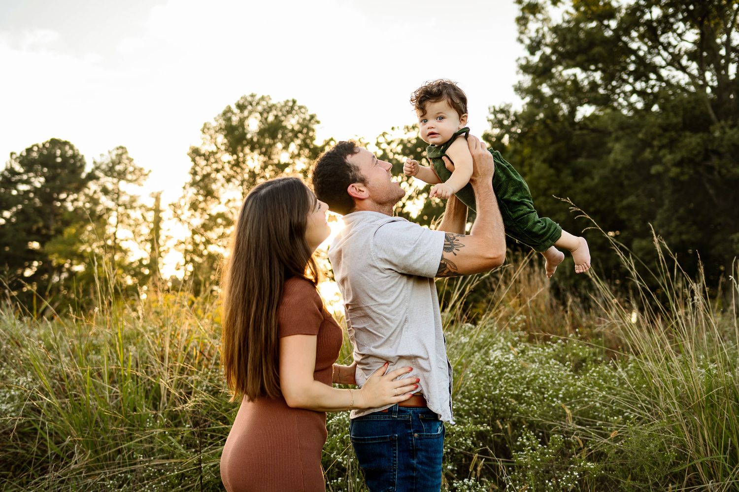Parents lifting baby during golden hour family photography session in Raleigh NC