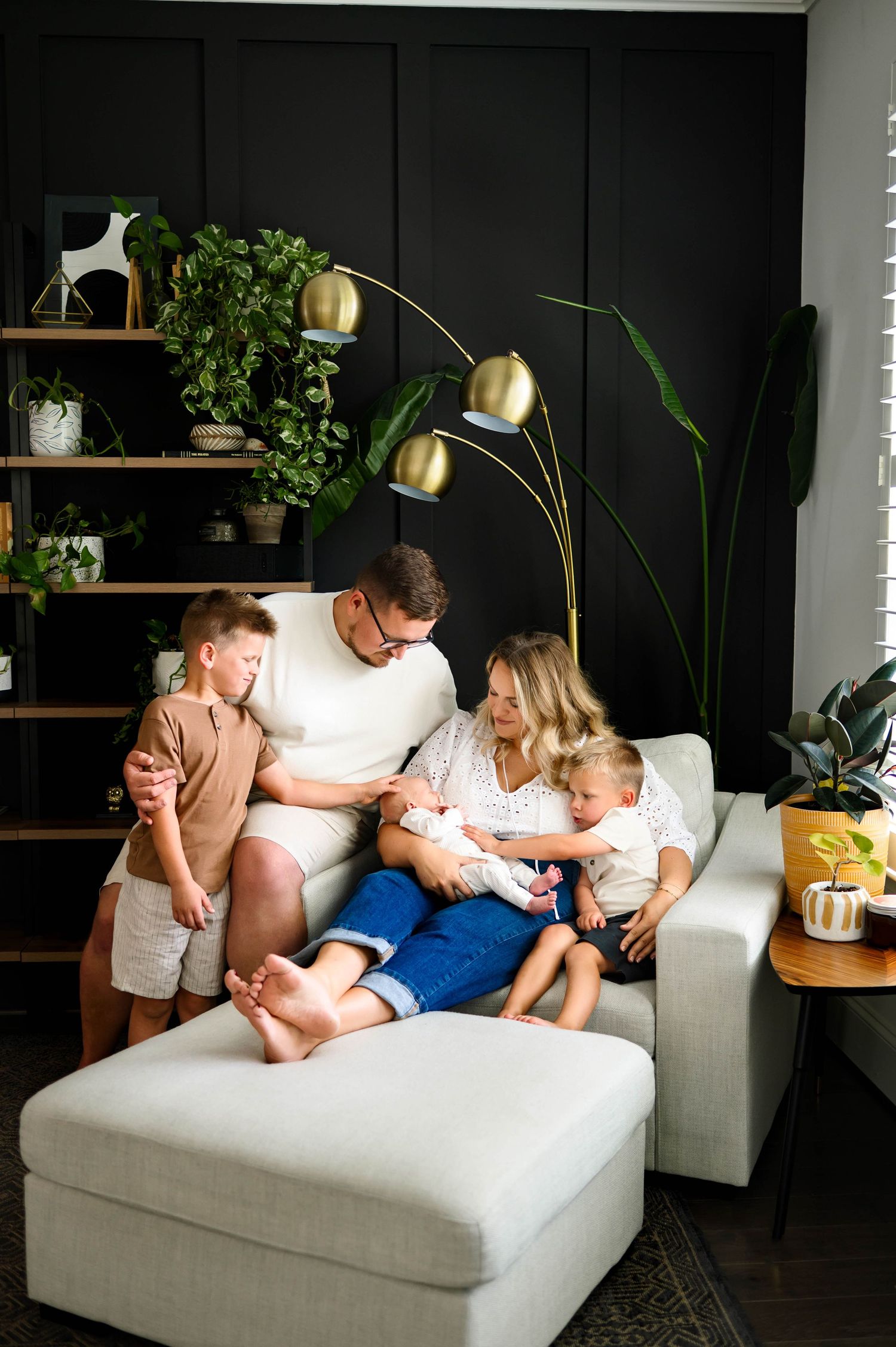 An in-home newborn photography session in Raleigh NC with parents and siblings gathered closely around their new baby brother