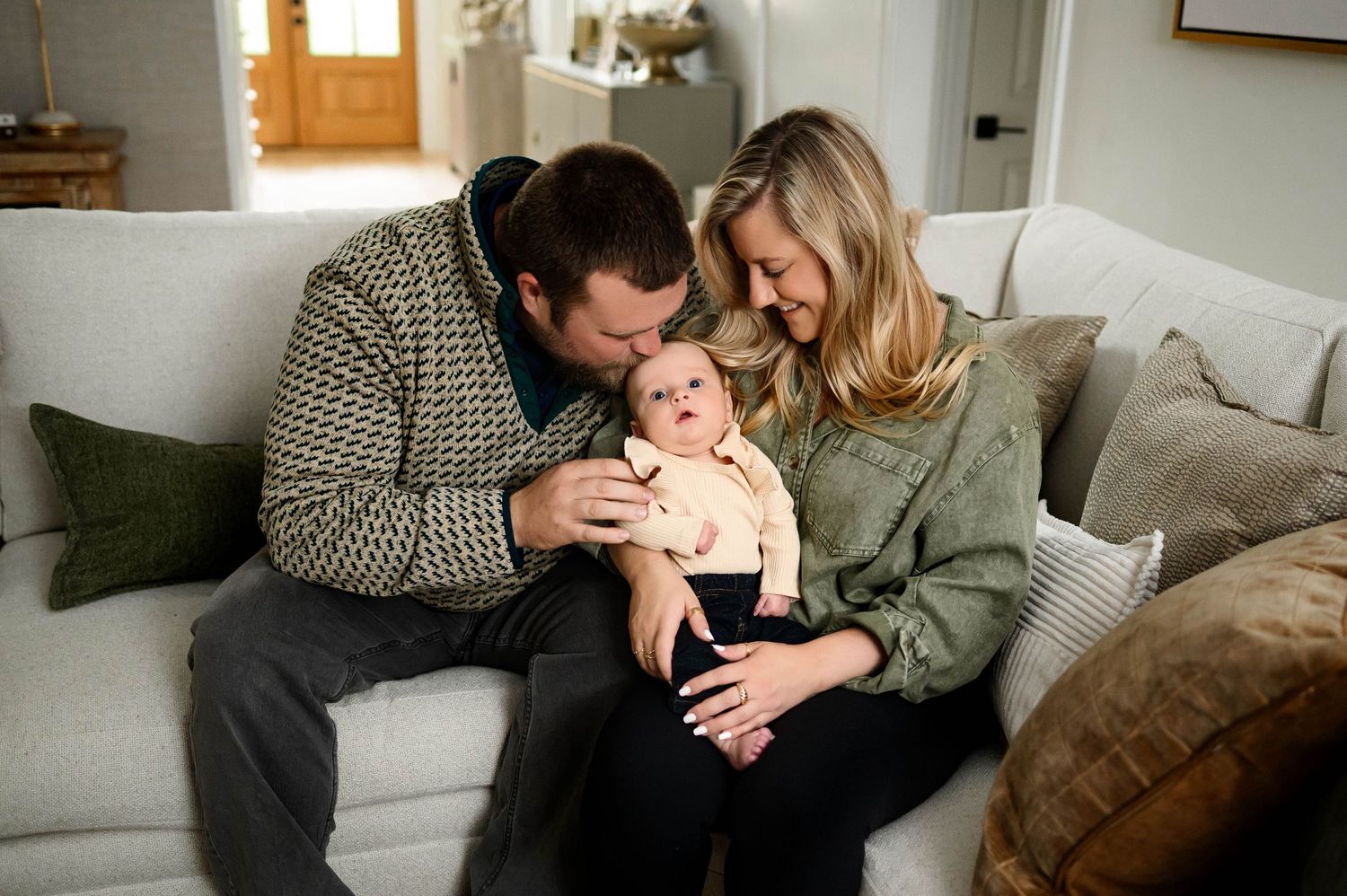 Parents sitting together with their baby during an in-home family photography session in Raleigh NC