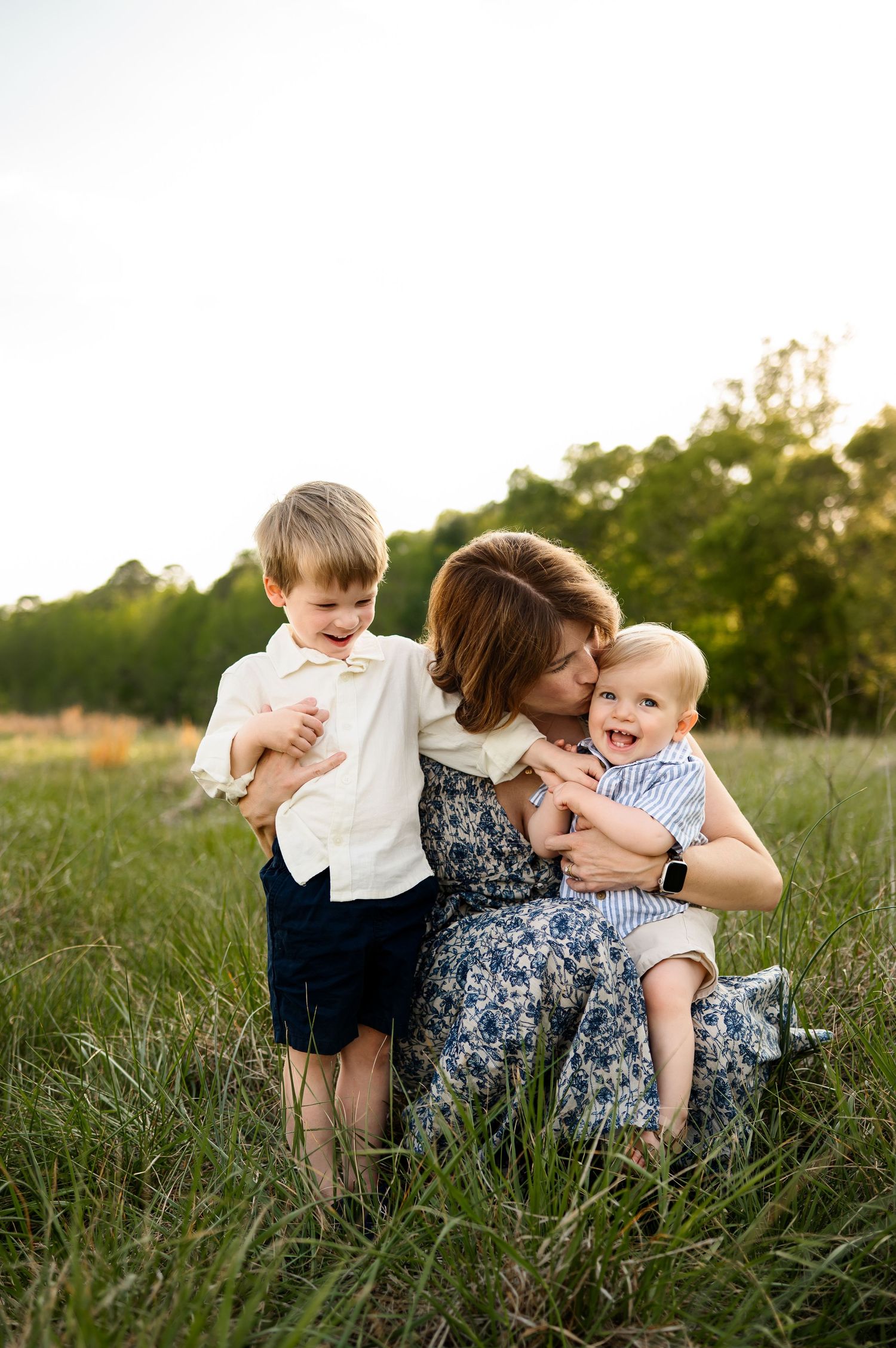 Raleigh family photographer Emma Branch captures giggling children cuddling with mother in outdoor lifestyle photography session
