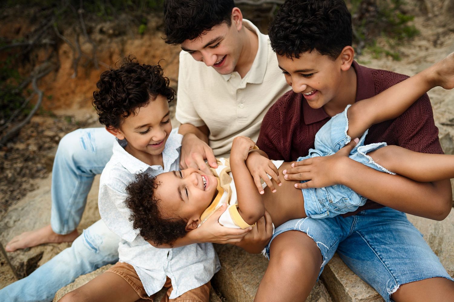 Raleigh family photographer captures a candid moment of brothers laughing and playing together outdoors