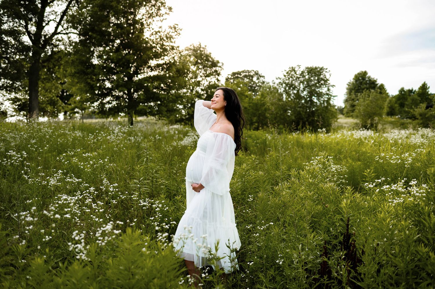 Expectant mother standing in a wildflower field during a maternity photography session near Durham NC