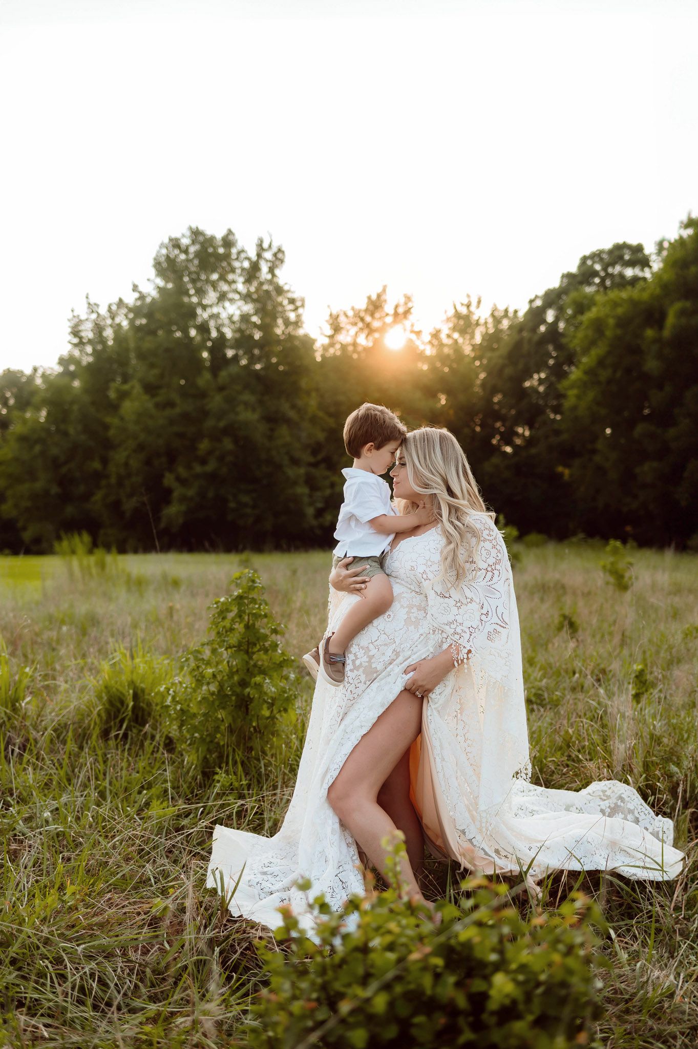 Expectant mother holding her toddler during a golden hour maternity photography session near Durham NC