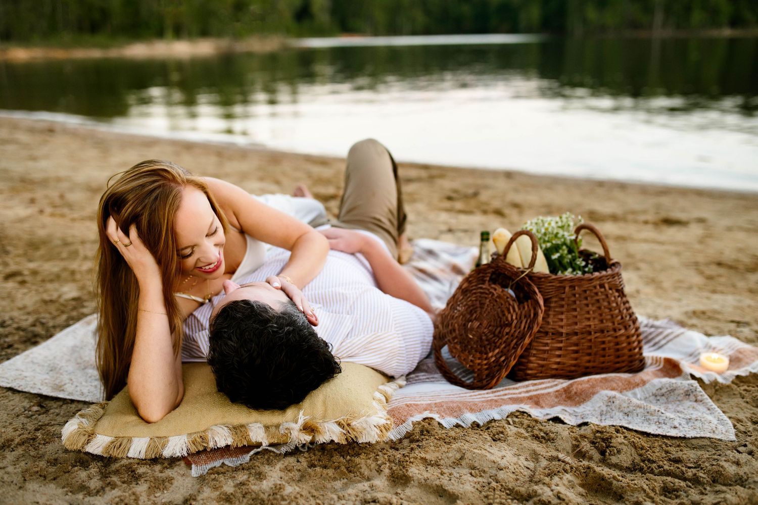 Couple lying on sandy beach during romantic sunset photoshoot with Raleigh maternity photographer Emma Branch Photography