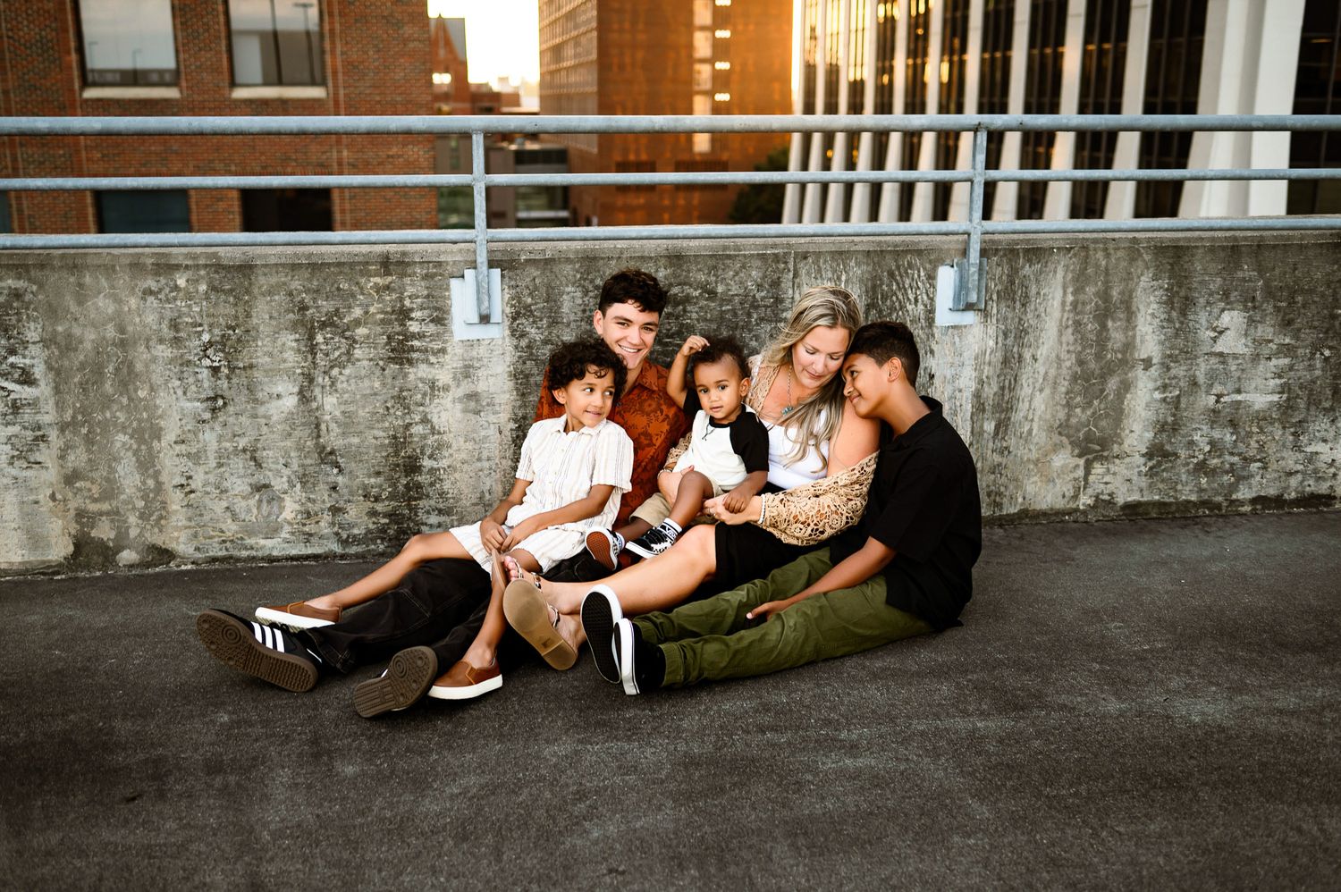 Family sitting together on a rooftop during a downtown Raleigh family photography session