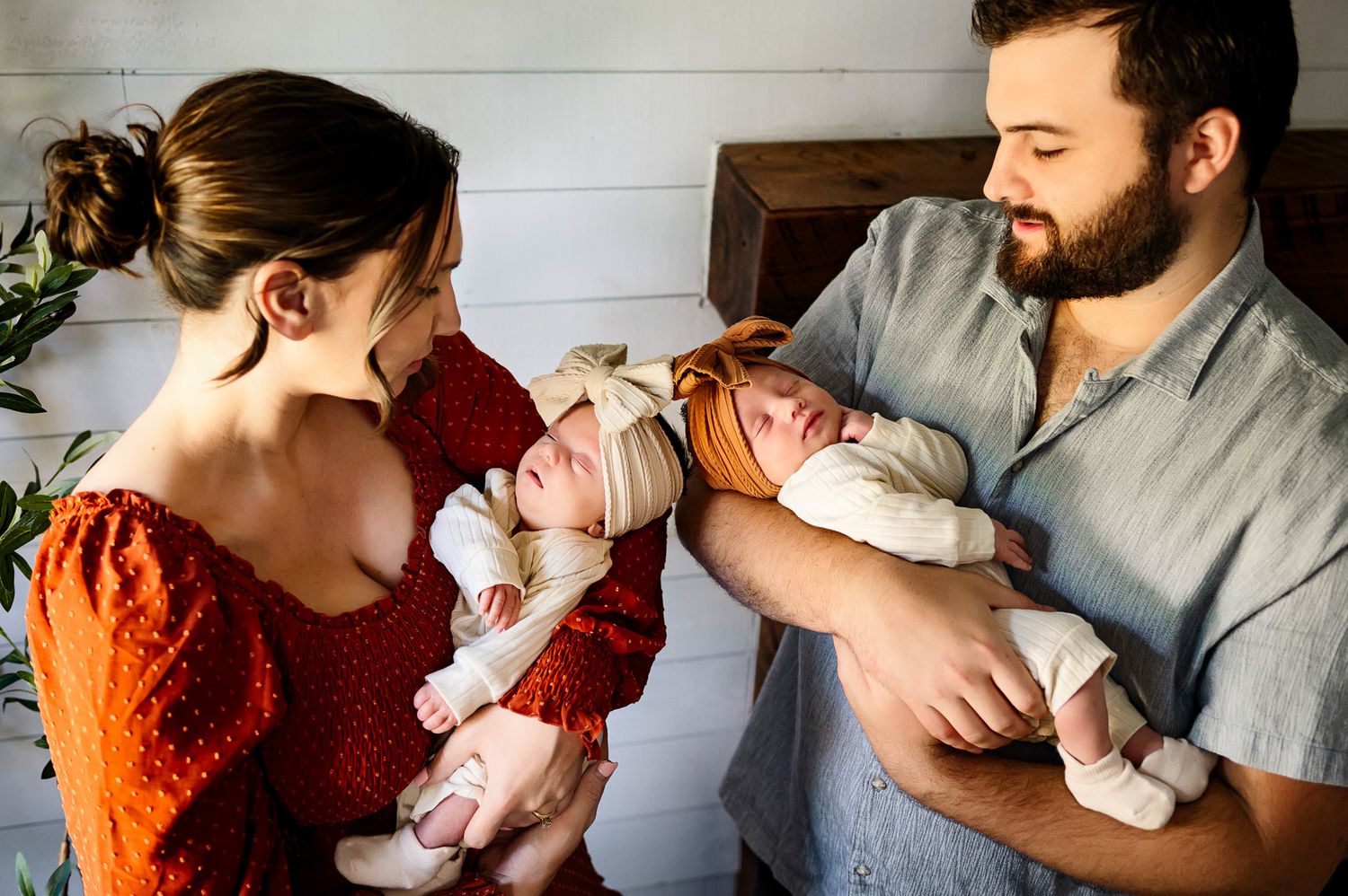 Parents holding their newborn twins during a natural light lifestyle newborn photography session near Raleigh NC