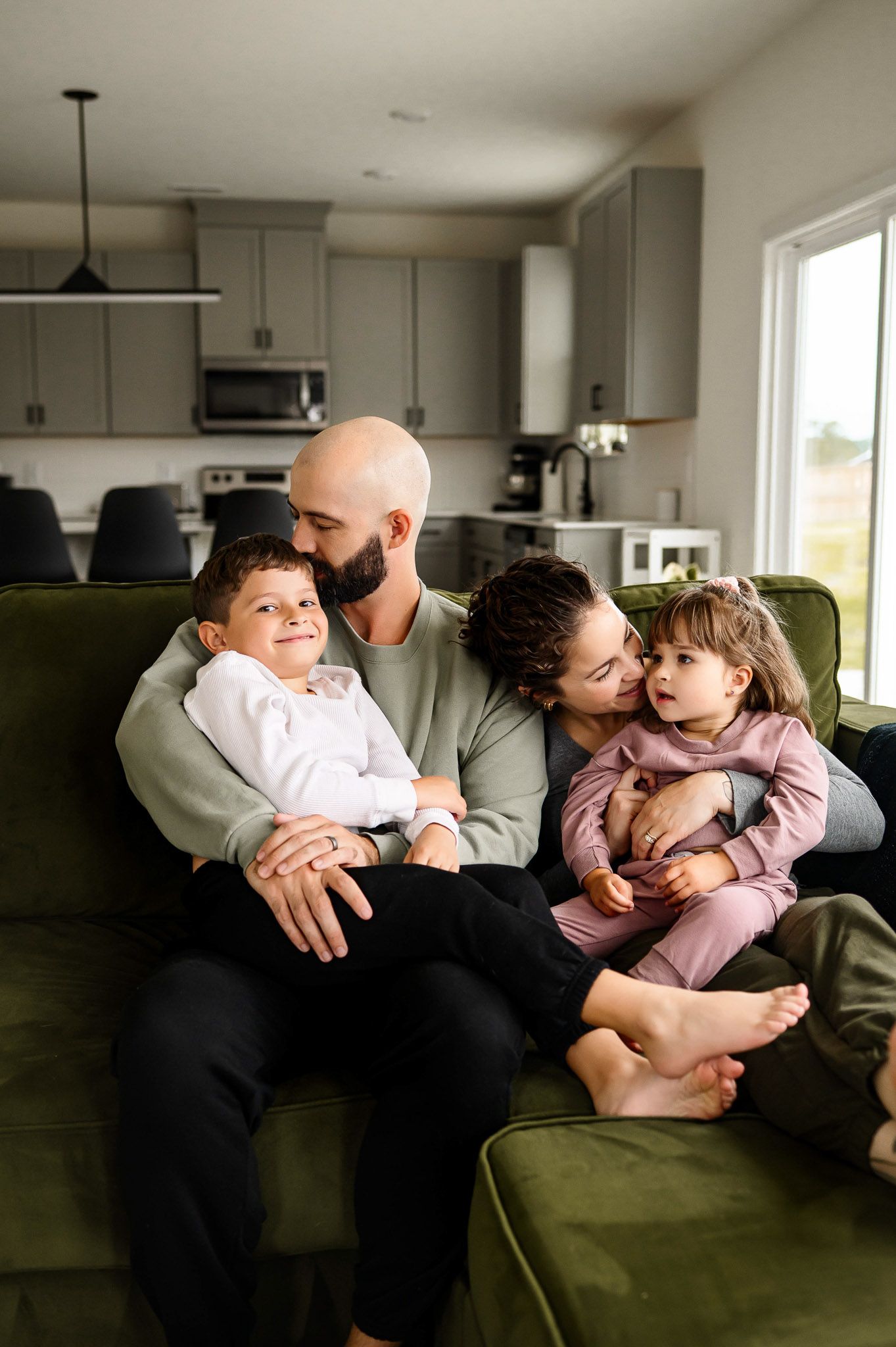 Family cuddling together on the couch during an in-home family photography session in Wake Forest North Carolina