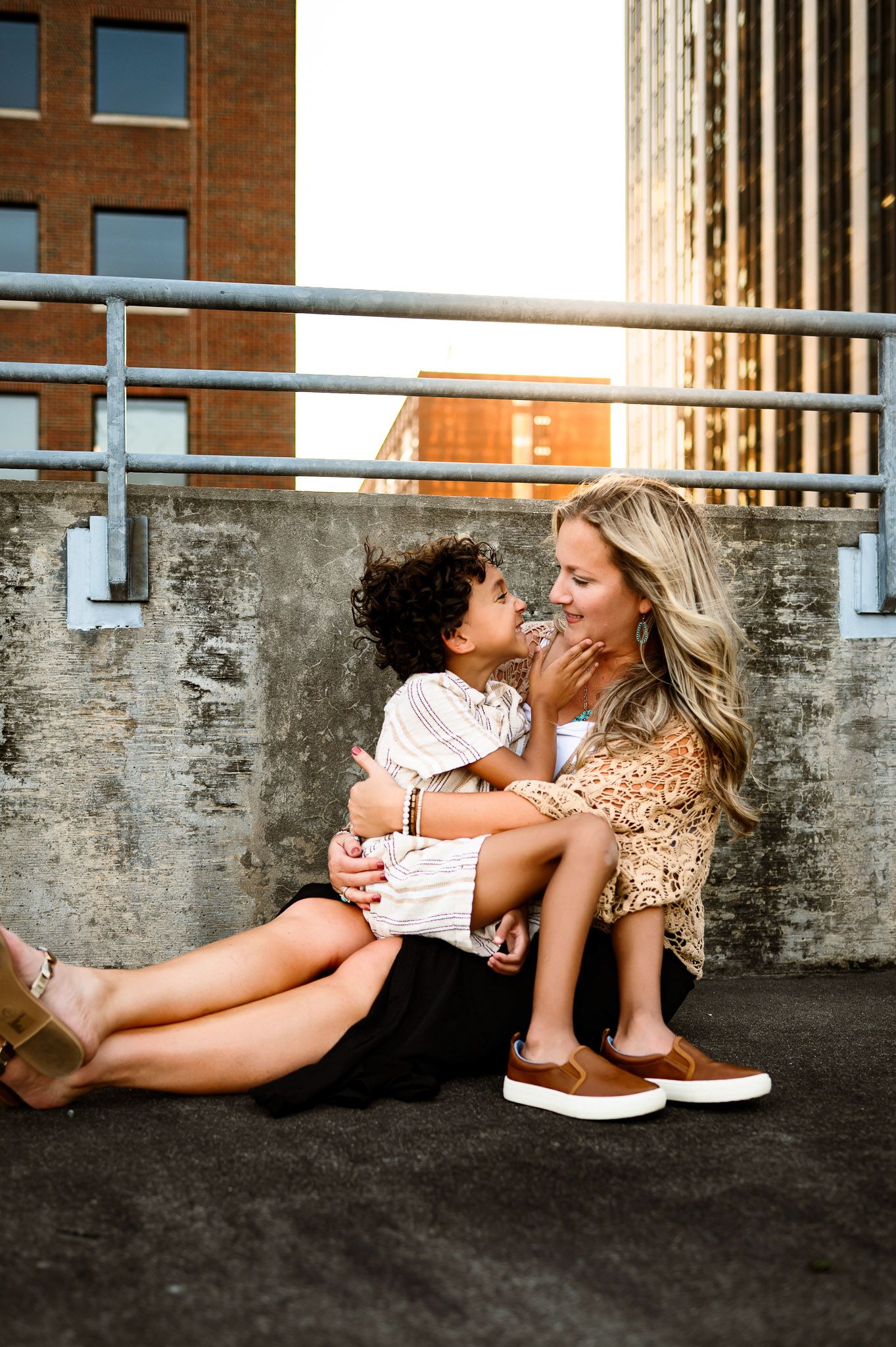 Mother holding her young son during golden hour on a rooftop in downtown Raleigh