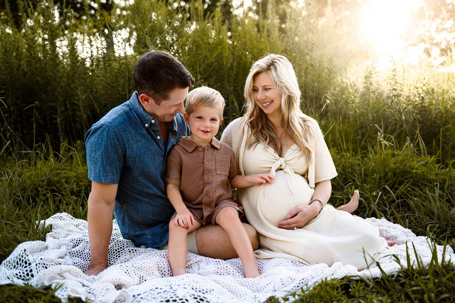 Family sitting together during a natural light maternity photography session near Raleigh North Carolina