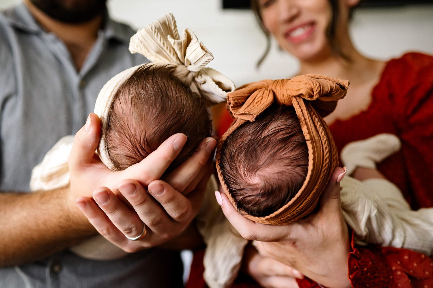 Close-up of newborn twins wearing bows during a lifestyle newborn photography session in Raleigh, North Carolina