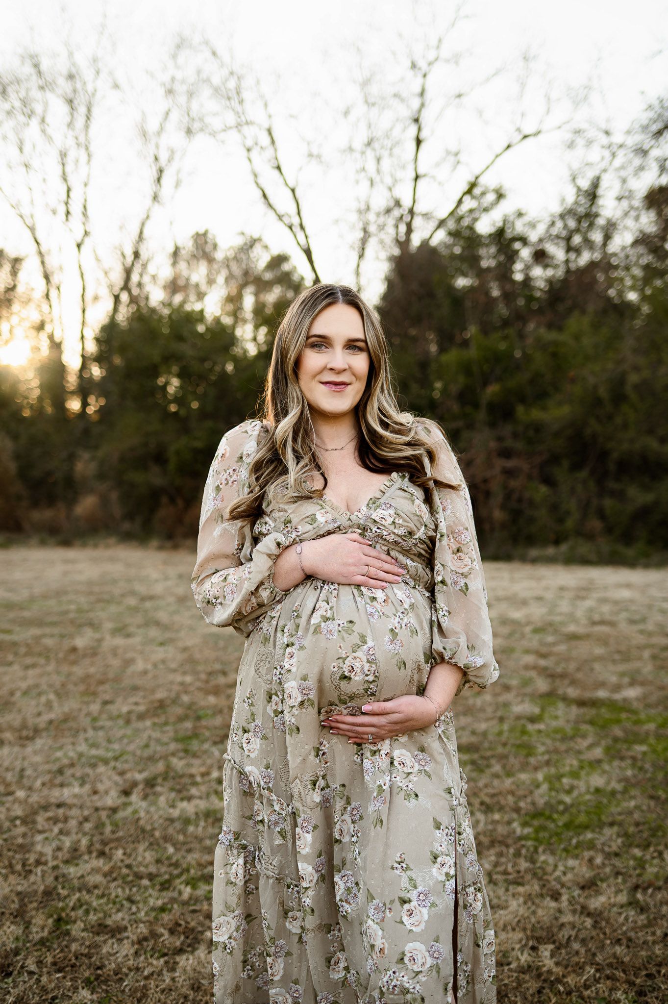 Pregnant mother standing in an open field during a natural light maternity photography session in Raleigh North Carolina