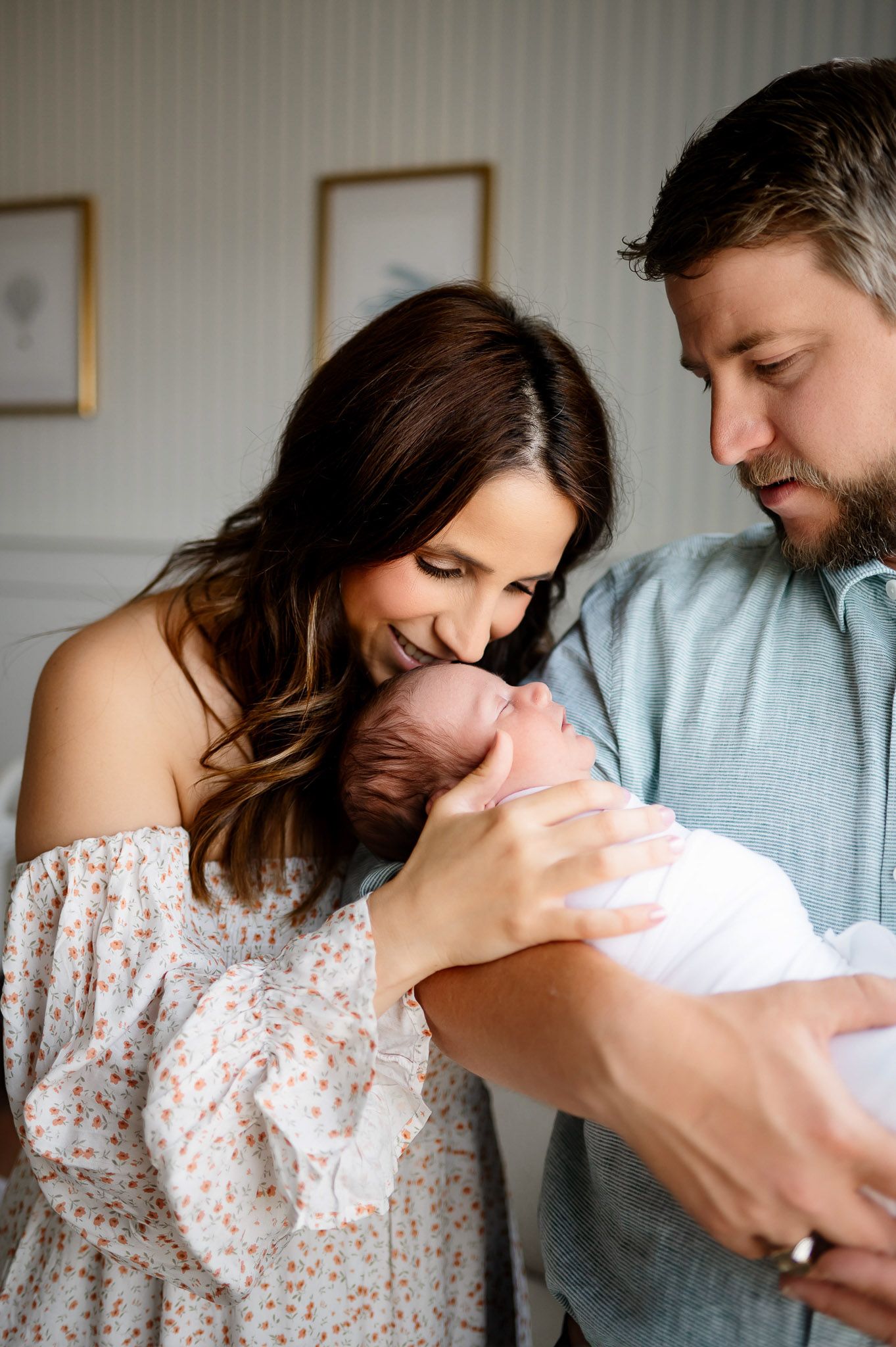 Parents admiring their newborn baby during a natural light lifestyle newborn photography session in Raleigh, North Carolina