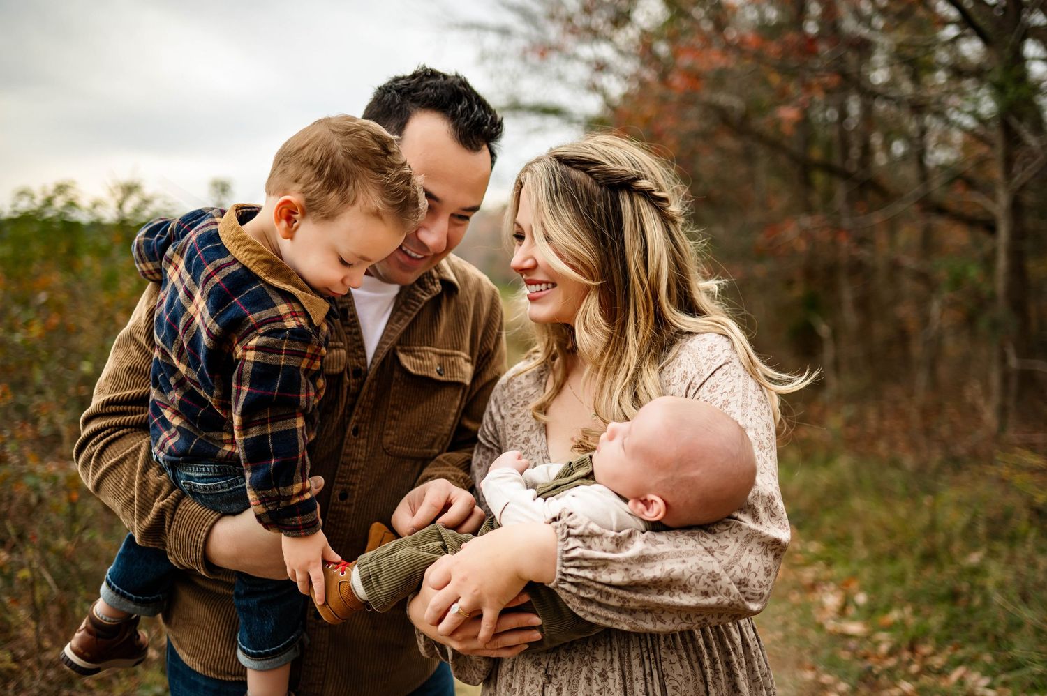 A couple in casual attire shares tender moments outdoors during a fall photoshoot session with Raleigh family photographer