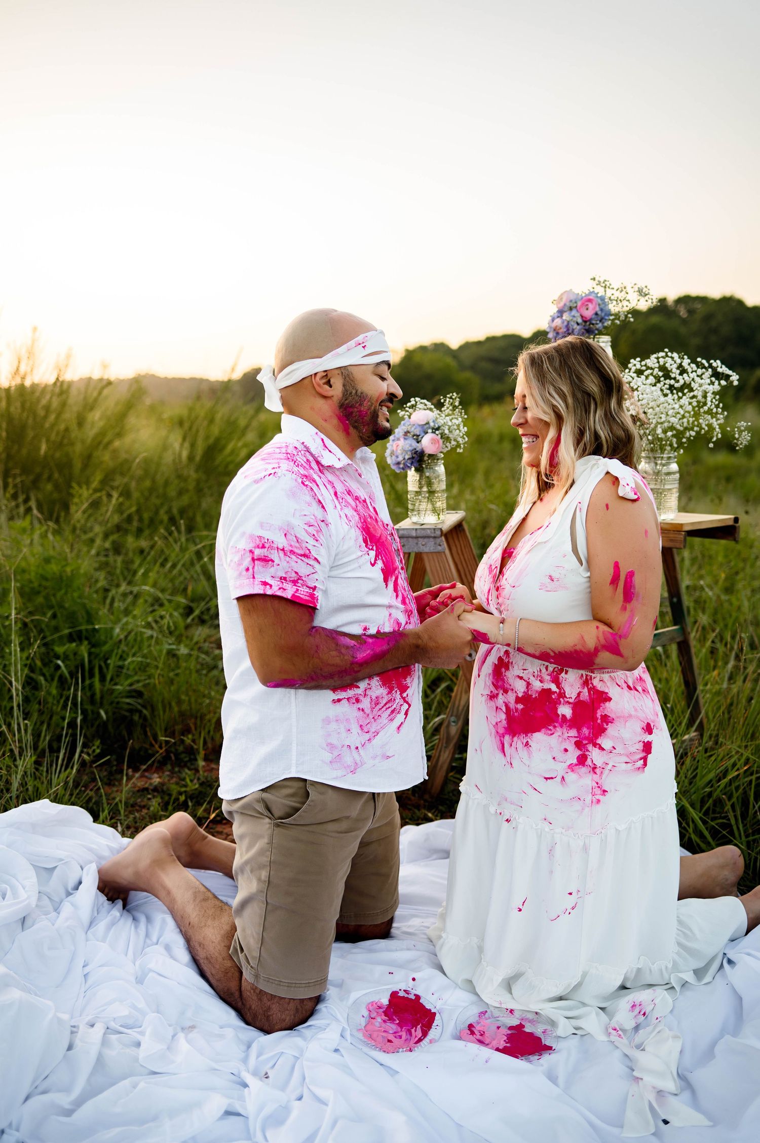 Expecting parents during a Raleigh gender reveal photography session before discovering pink paint revealing they are having a baby girl