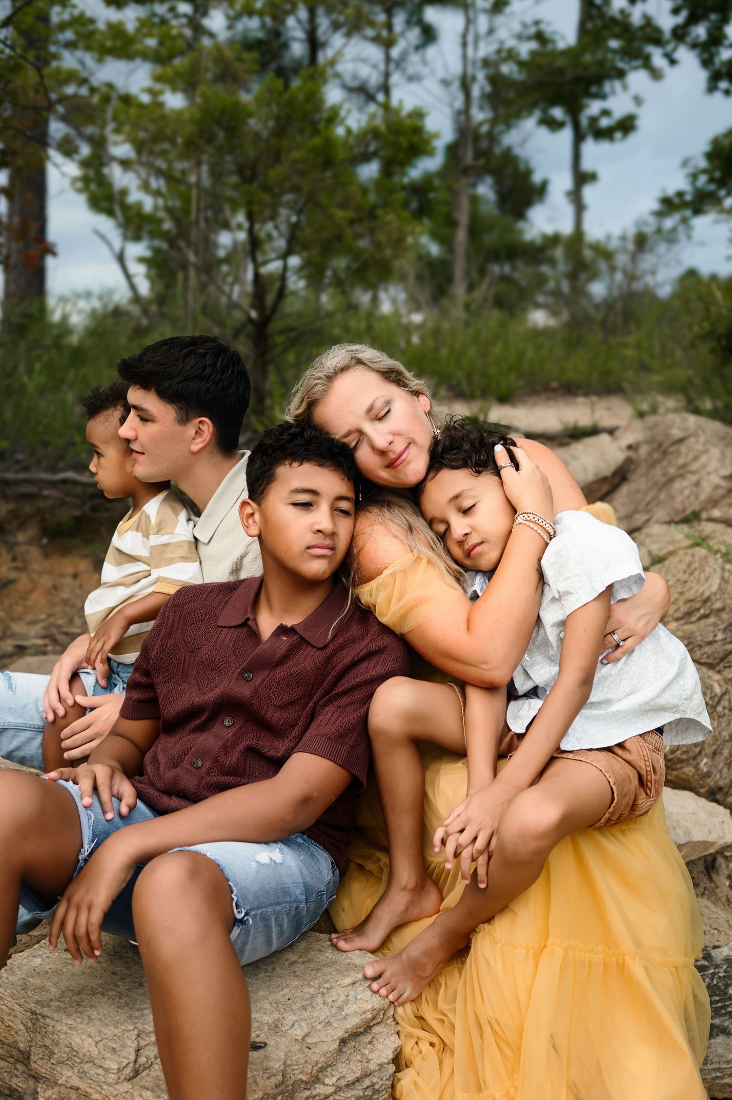 Mom cuddling with her four children during an outdoor Raleigh family photography session
