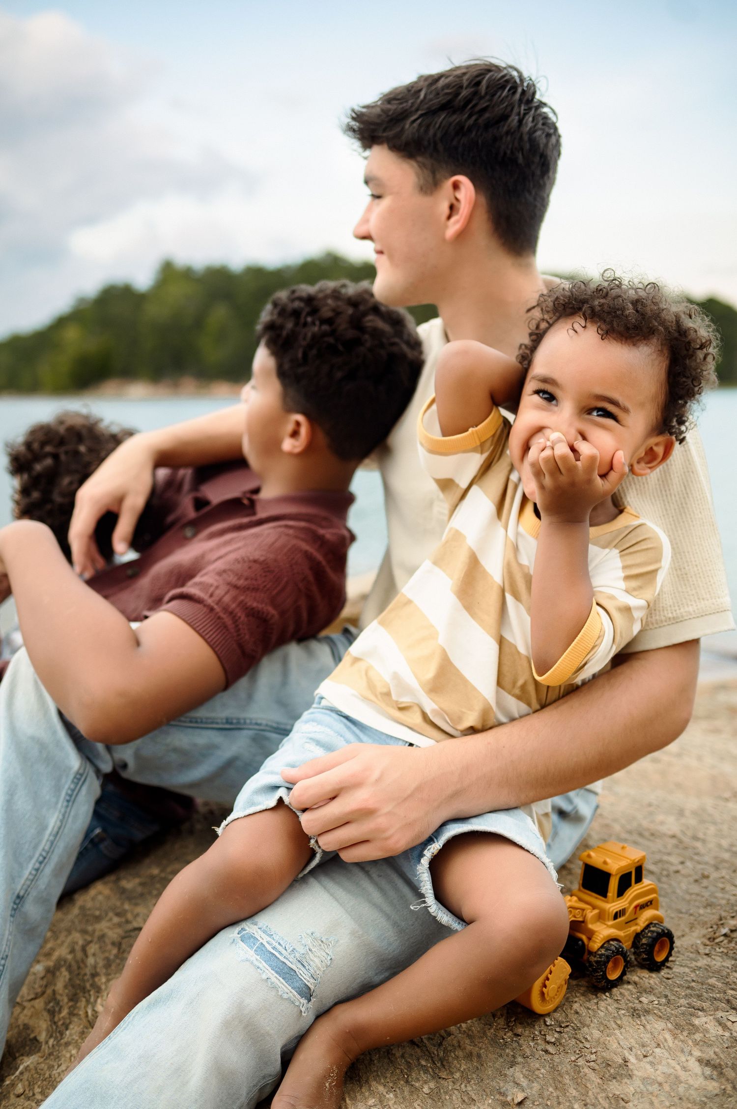 Brothers sitting together by the lake during an outdoor family photography session in Raleigh, NC