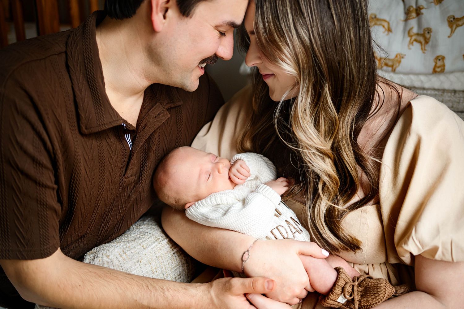 Parents cuddling their newborn during a relaxed lifestyle newborn photography session at home in Wake Forest NC