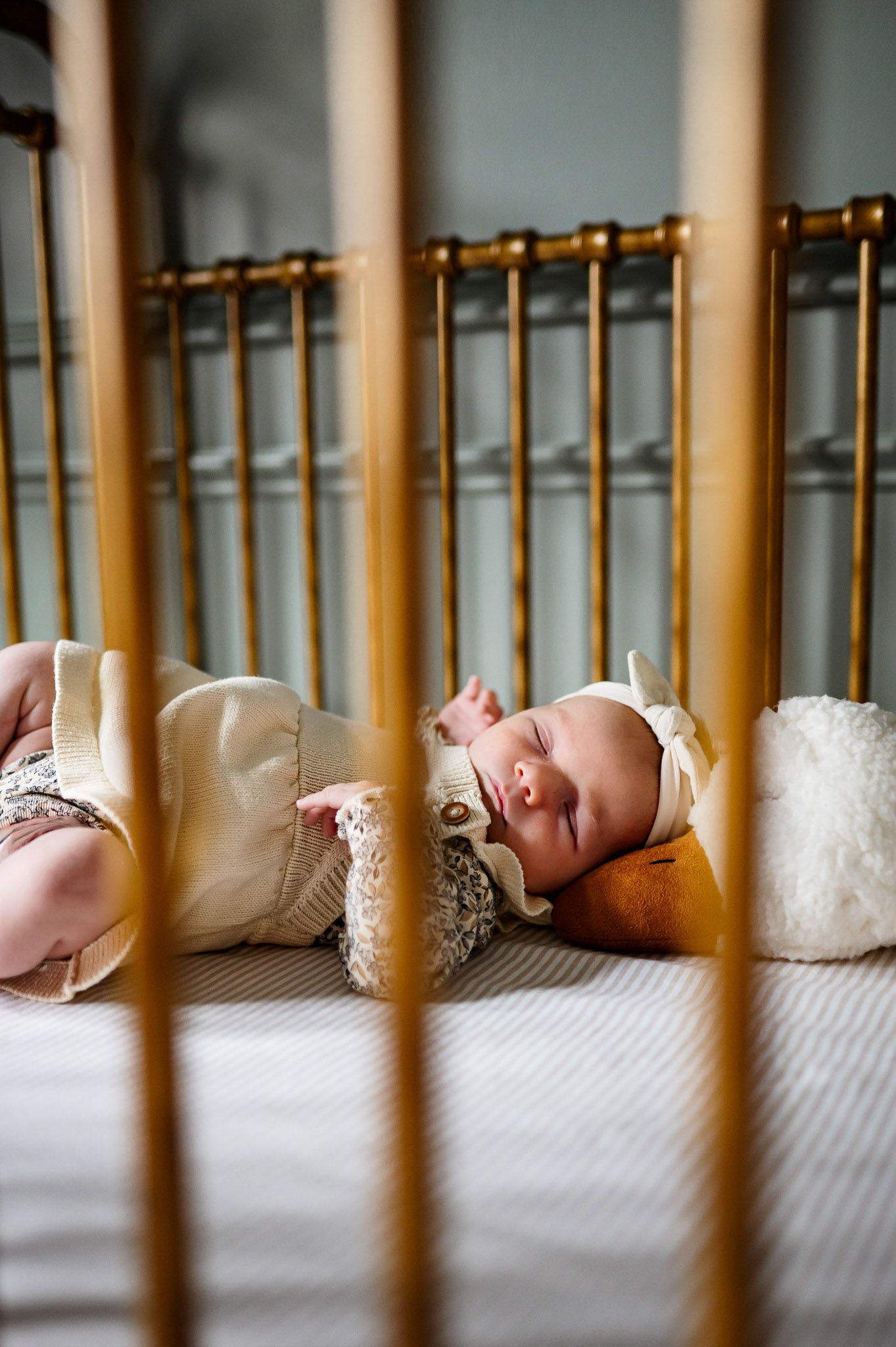 Sleeping newborn baby resting peacefully in a crib during a natural lifestyle newborn photography session at home