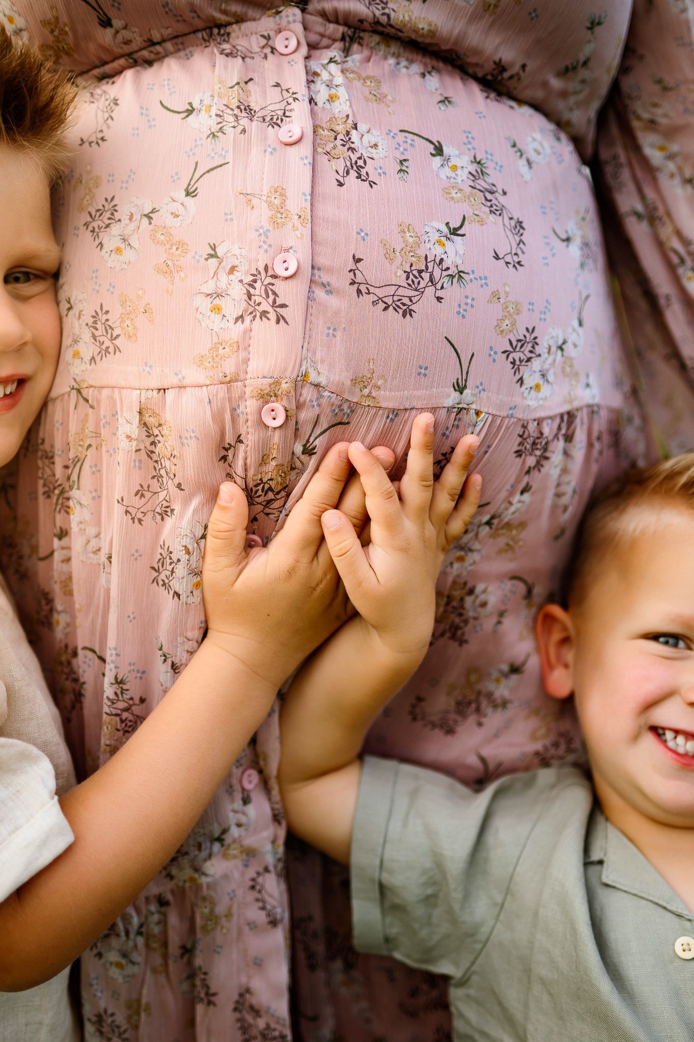Young siblings touching their mother's baby bump during a maternity photography session in Raleigh NC