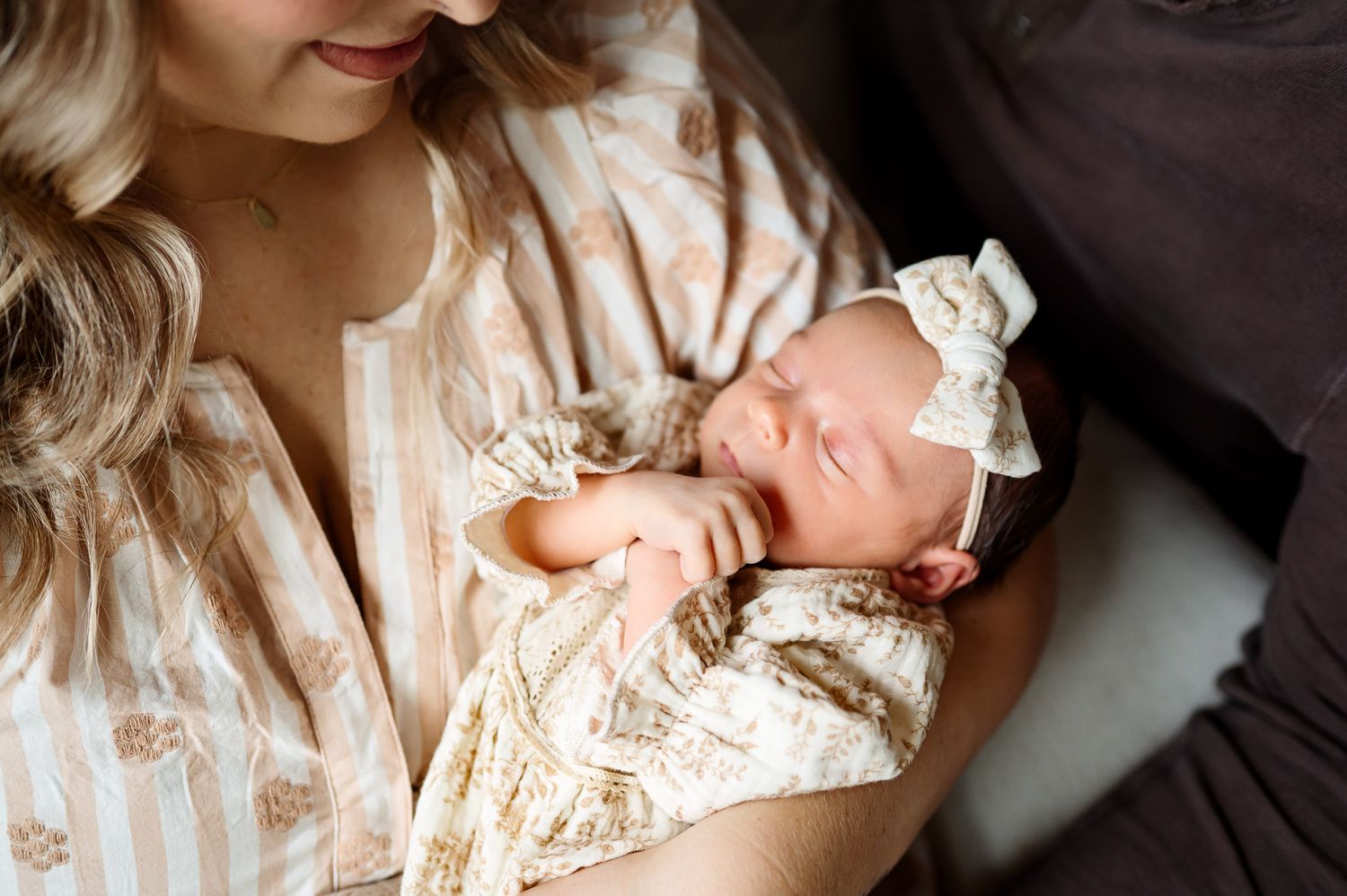Mother holding her sleeping newborn baby during a natural light lifestyle newborn photography session in Raleigh NC