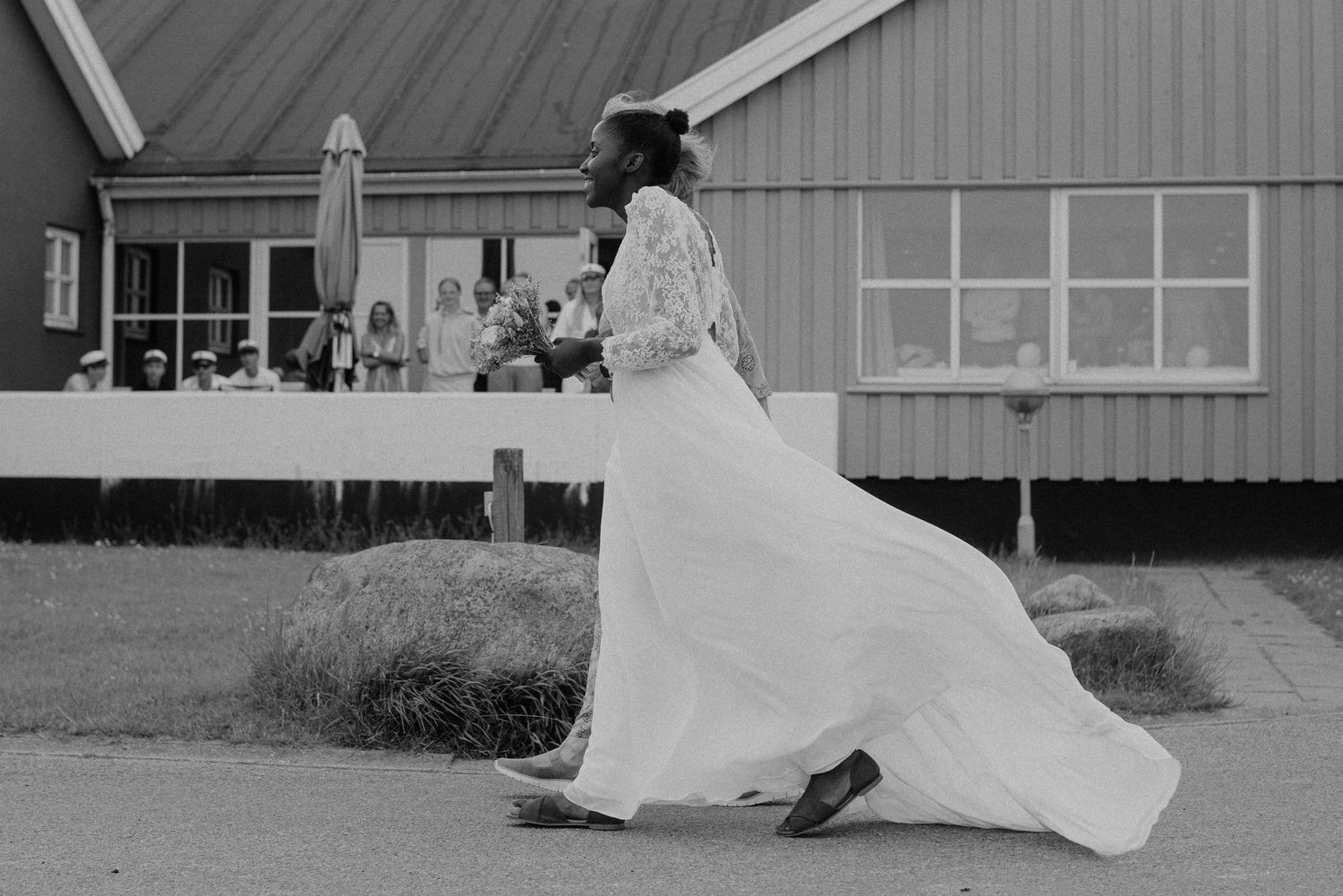 Black and white photo of a flowing wedding dress moving gracefully in the wind.