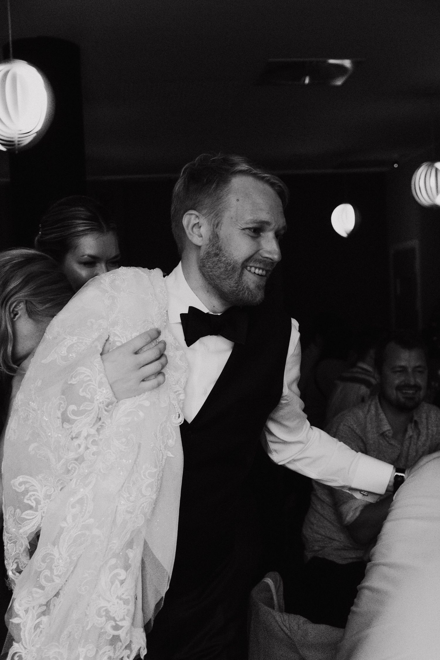 Black and white photo sequence showing people laughing and dancing at what appears to be a party or celebration.