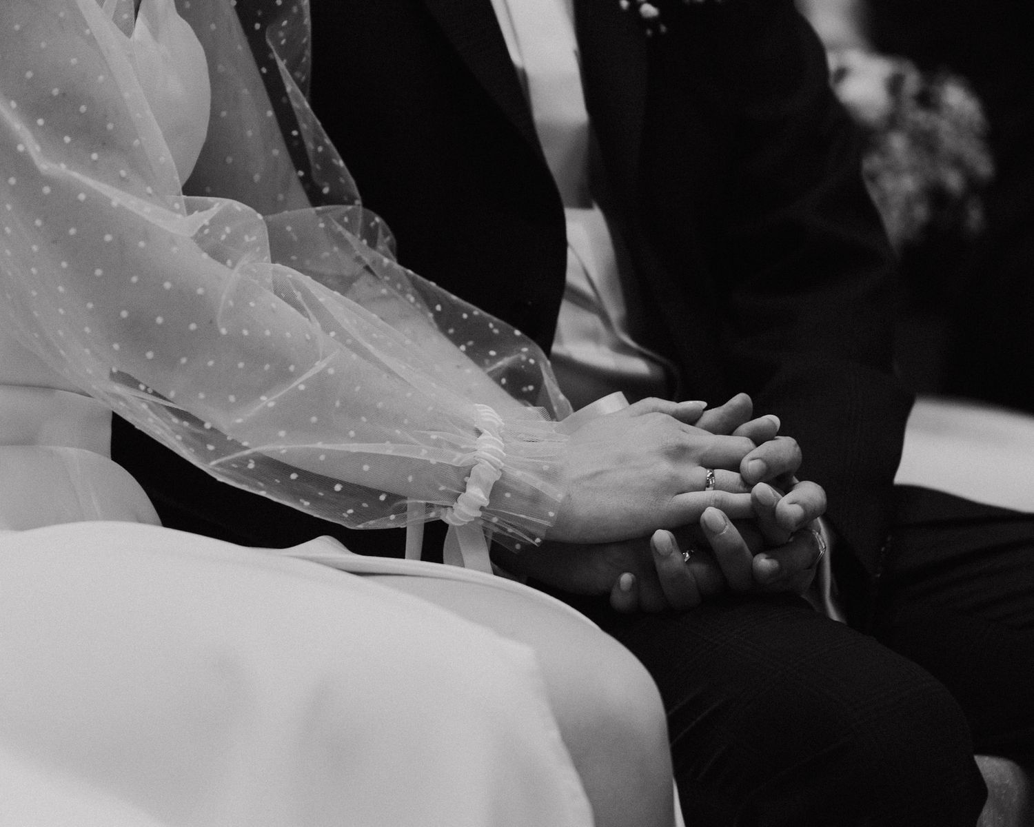Black and white close-up of elegant wedding dress details.