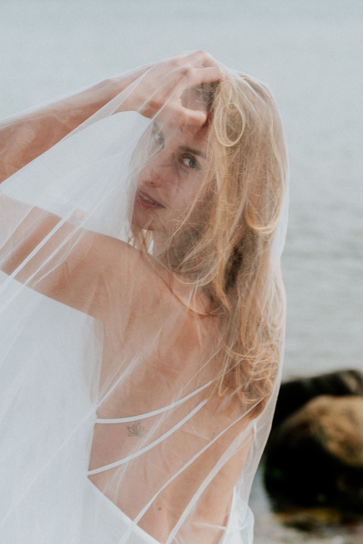 A soft ethereal bridal portrait series showing a veil flowing in the wind against a light background.