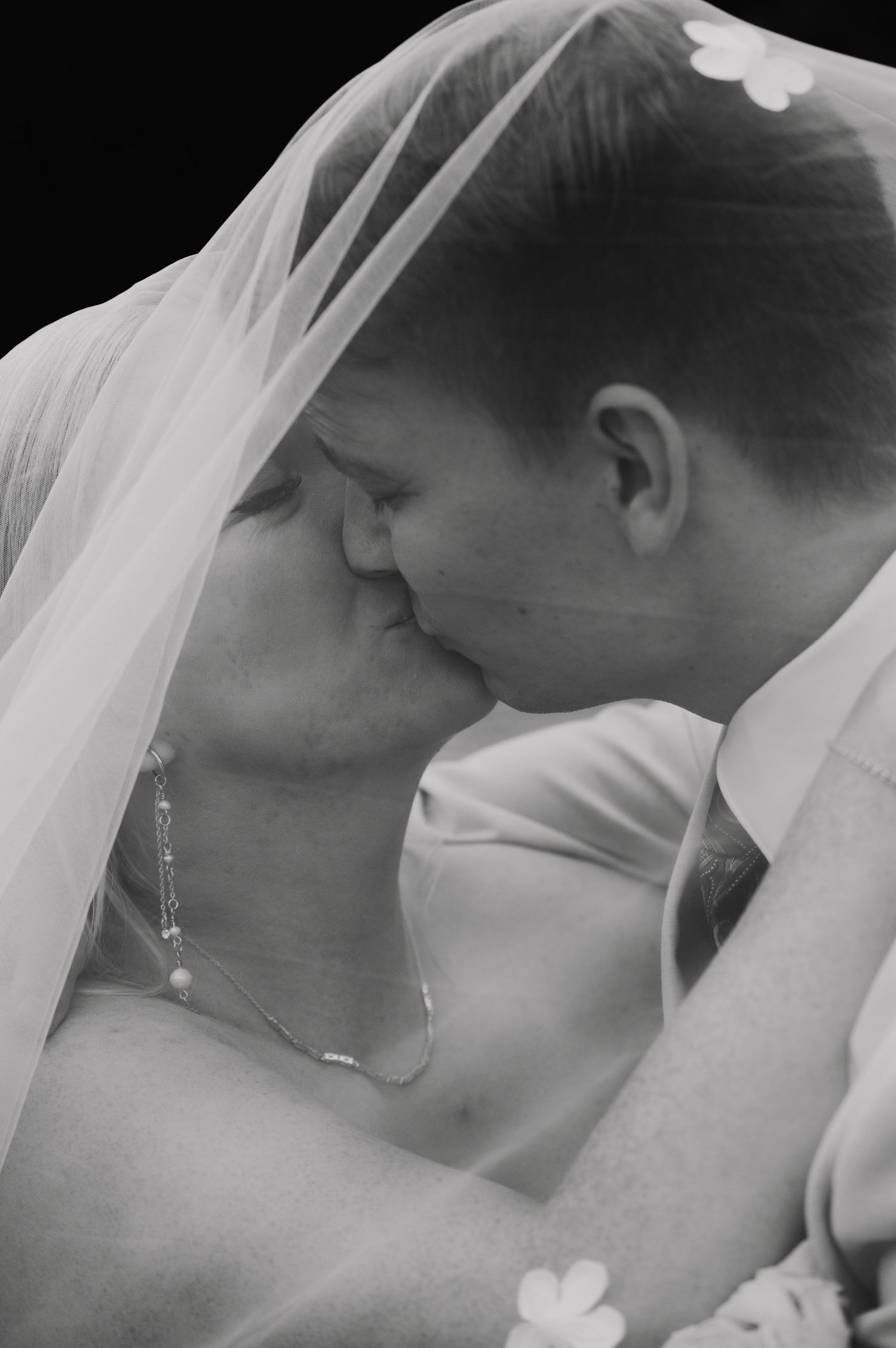 Black and white romantic portrait through a delicate bridal veil.